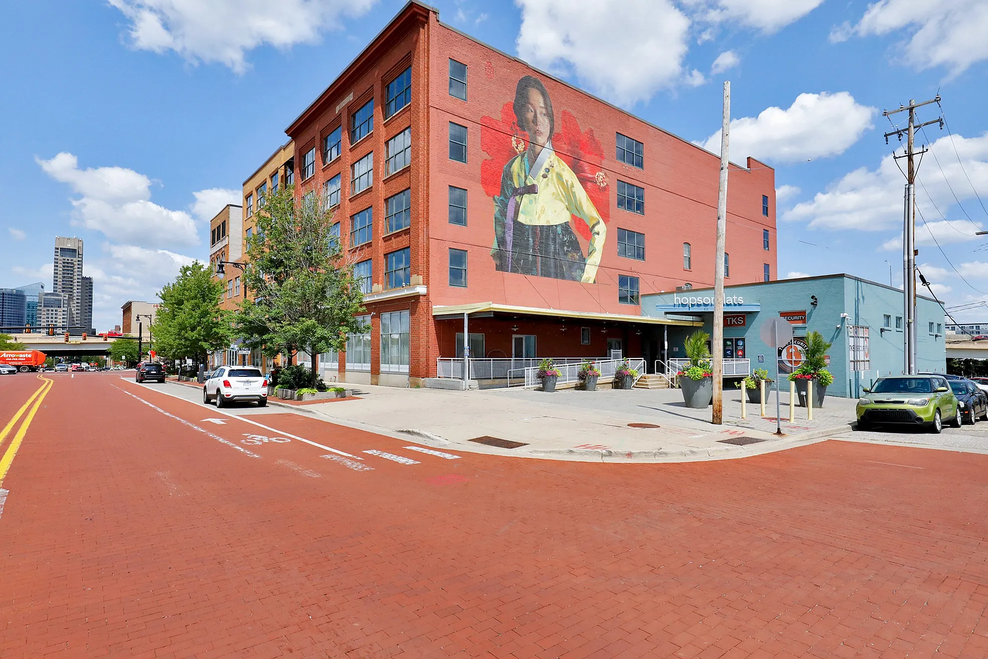 Chic urban apartment building with vibrant mural, showcasing a prime city location with modern aesthetics and convenient street access.