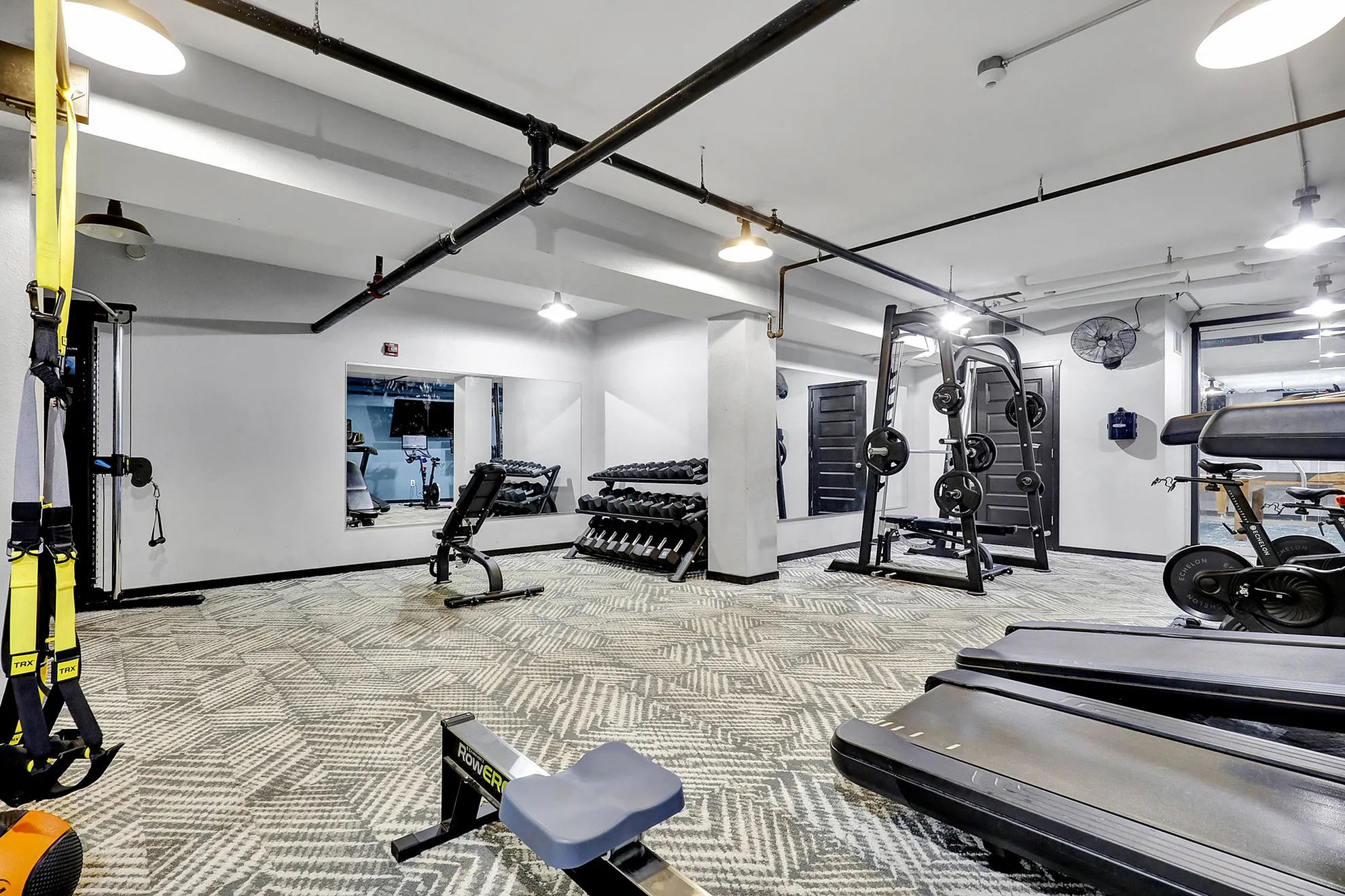 Modern gym facility featuring state-of-the-art equipment, free weights, and a sleek workout area for fitness enthusiasts.