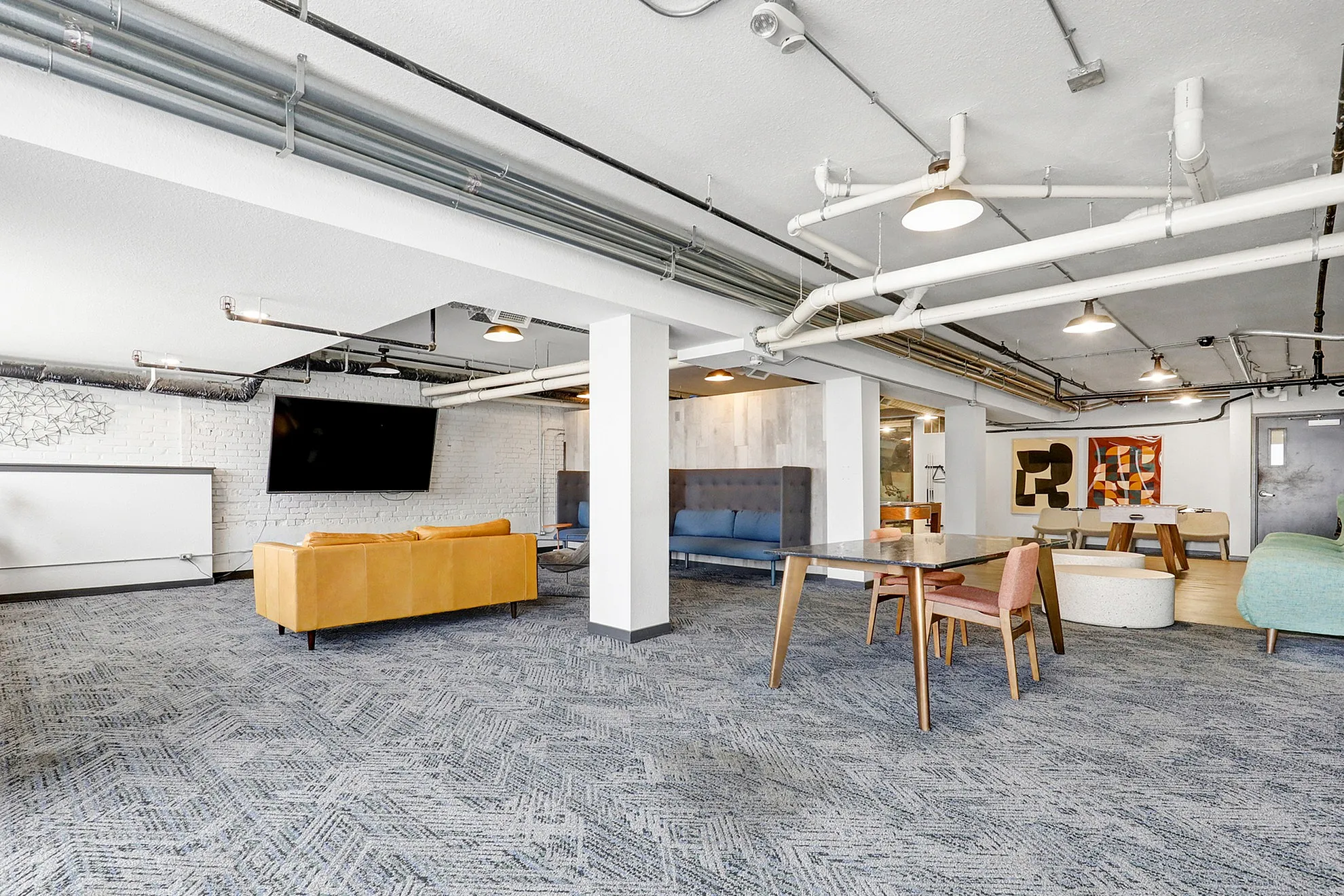 Modern communal living area with chic furniture, stylish decor, and bright lighting, perfect for social gatherings.