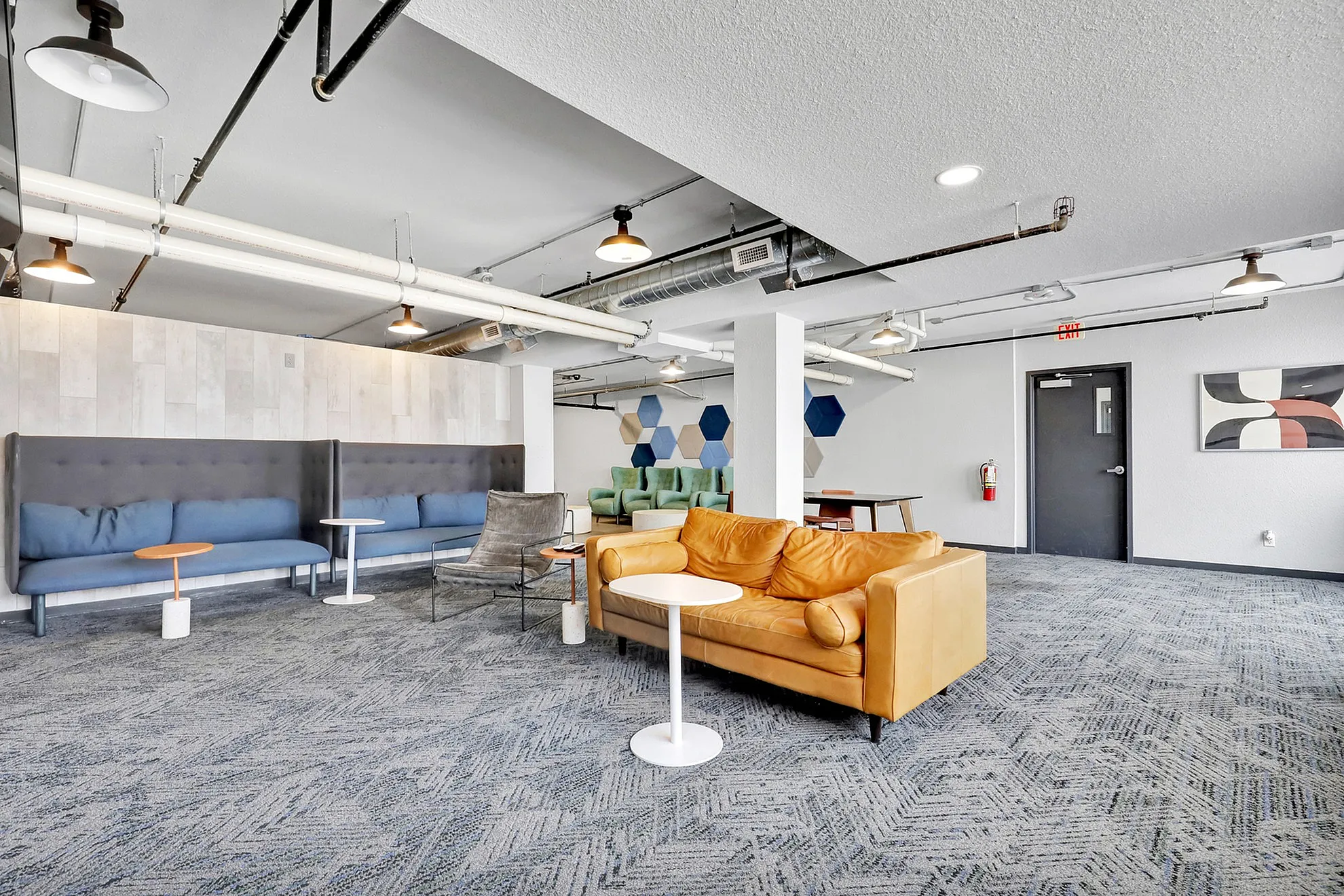 Modern community lounge featuring stylish seating with vibrant yellow couches, sleek tables, and contemporary wall decor.