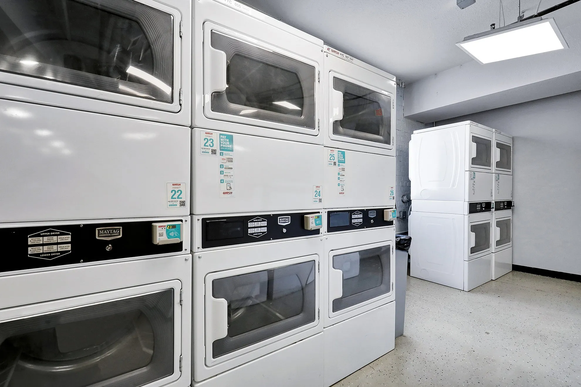 Modern laundry room featuring efficient stackable washers and dryers in a bright, clean space.