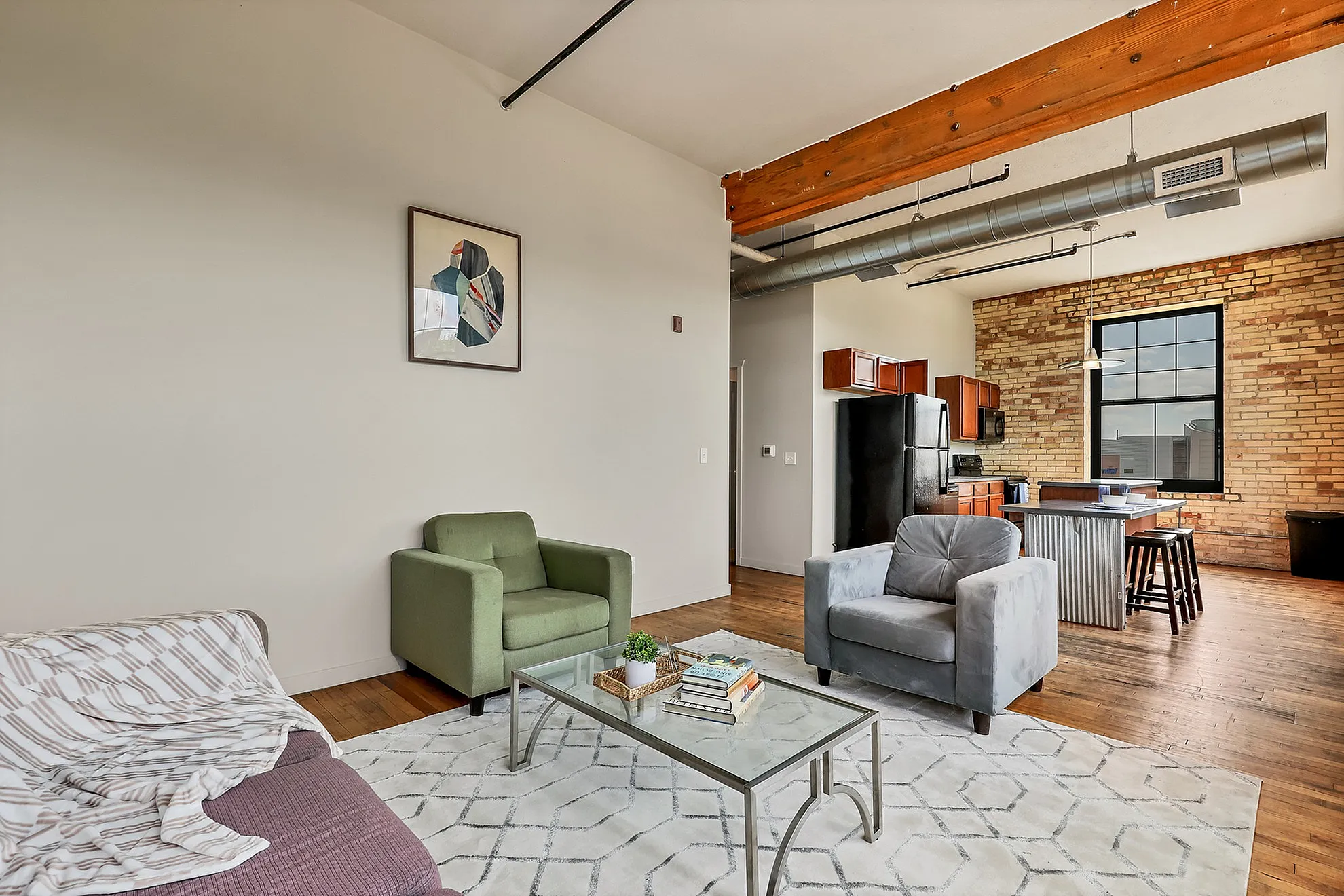 Chic loft apartment with exposed brick, modern furnishings, and an open-concept layout featuring a stylish kitchen and inviting living space.