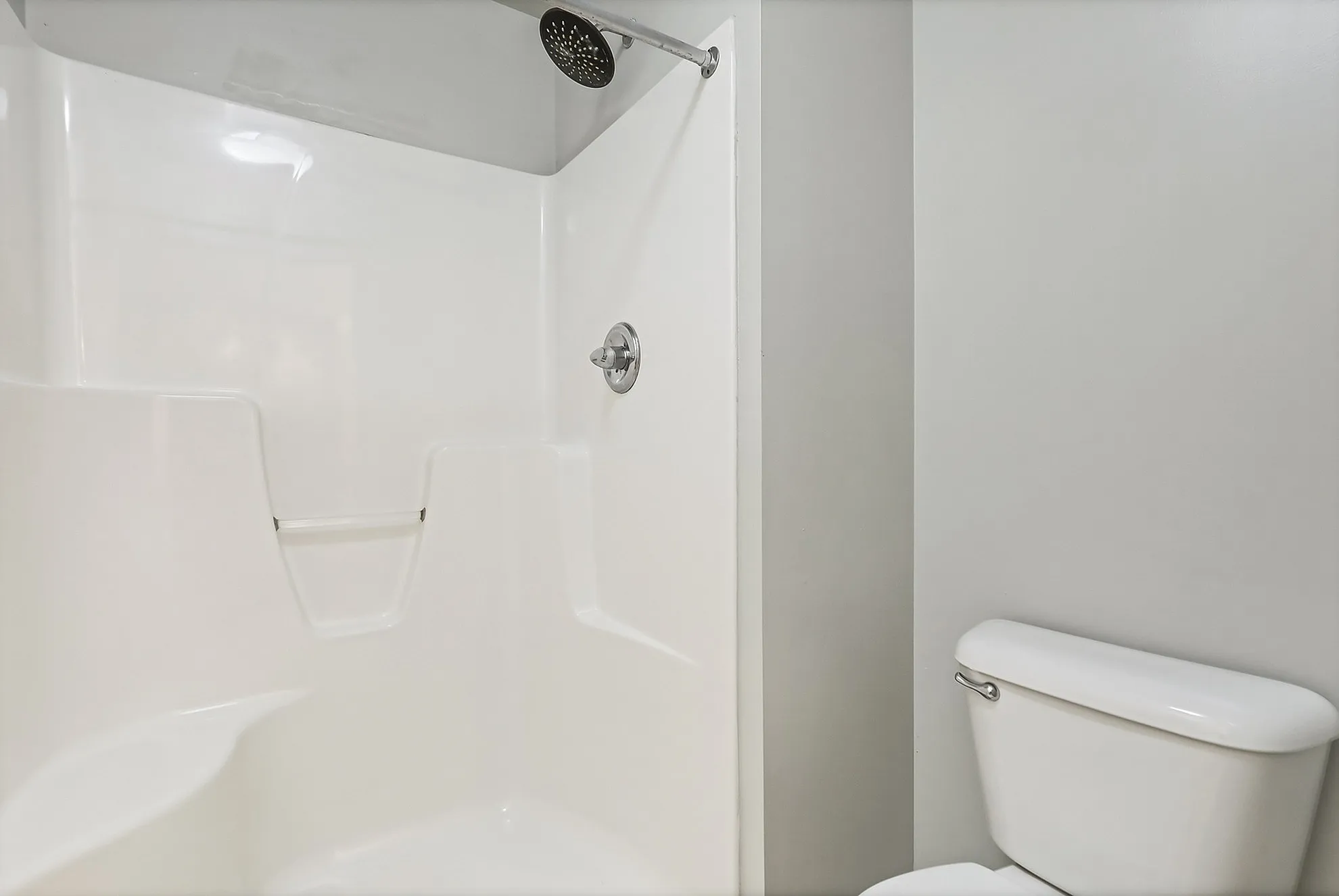 Modern bathroom featuring a sleek white shower and toilet, highlighting a clean and inviting design.