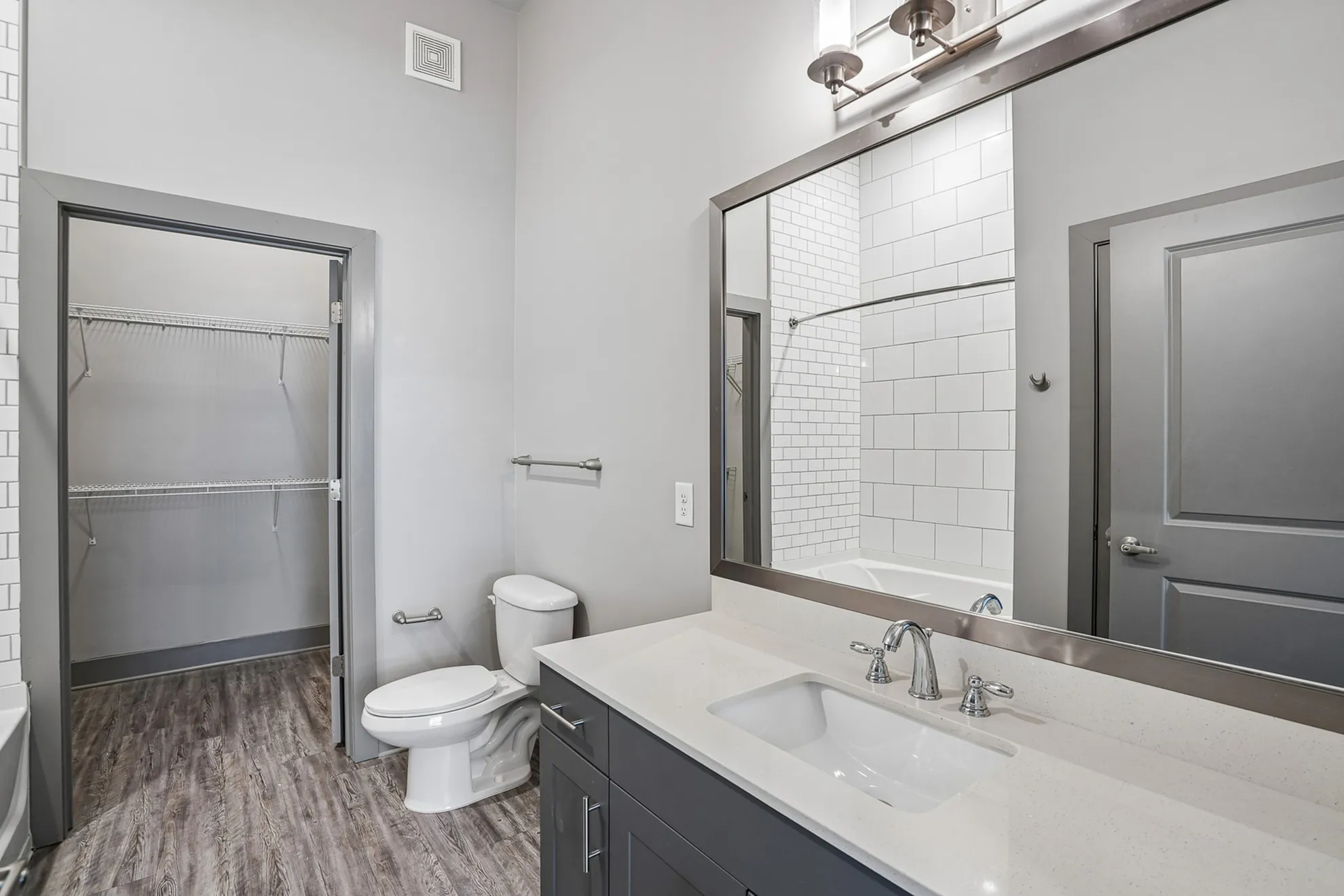 Modern bathroom featuring sleek cabinetry, spacious counters, and a walk-in closet.
