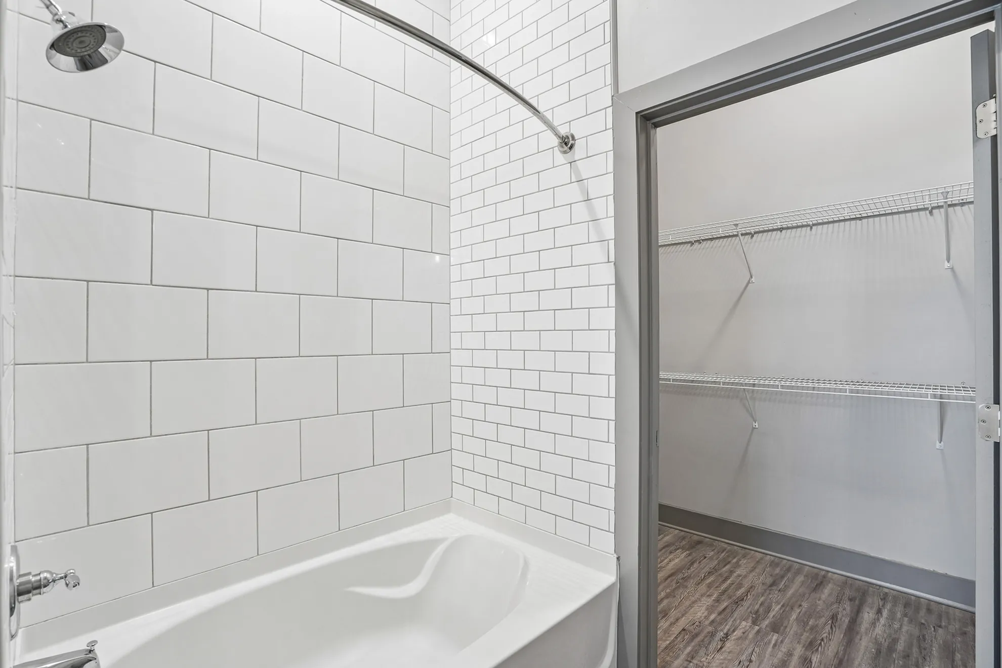 Sleek modern bathroom with white subway tiles and a convenient walk-in closet, perfect for stylish urban living.