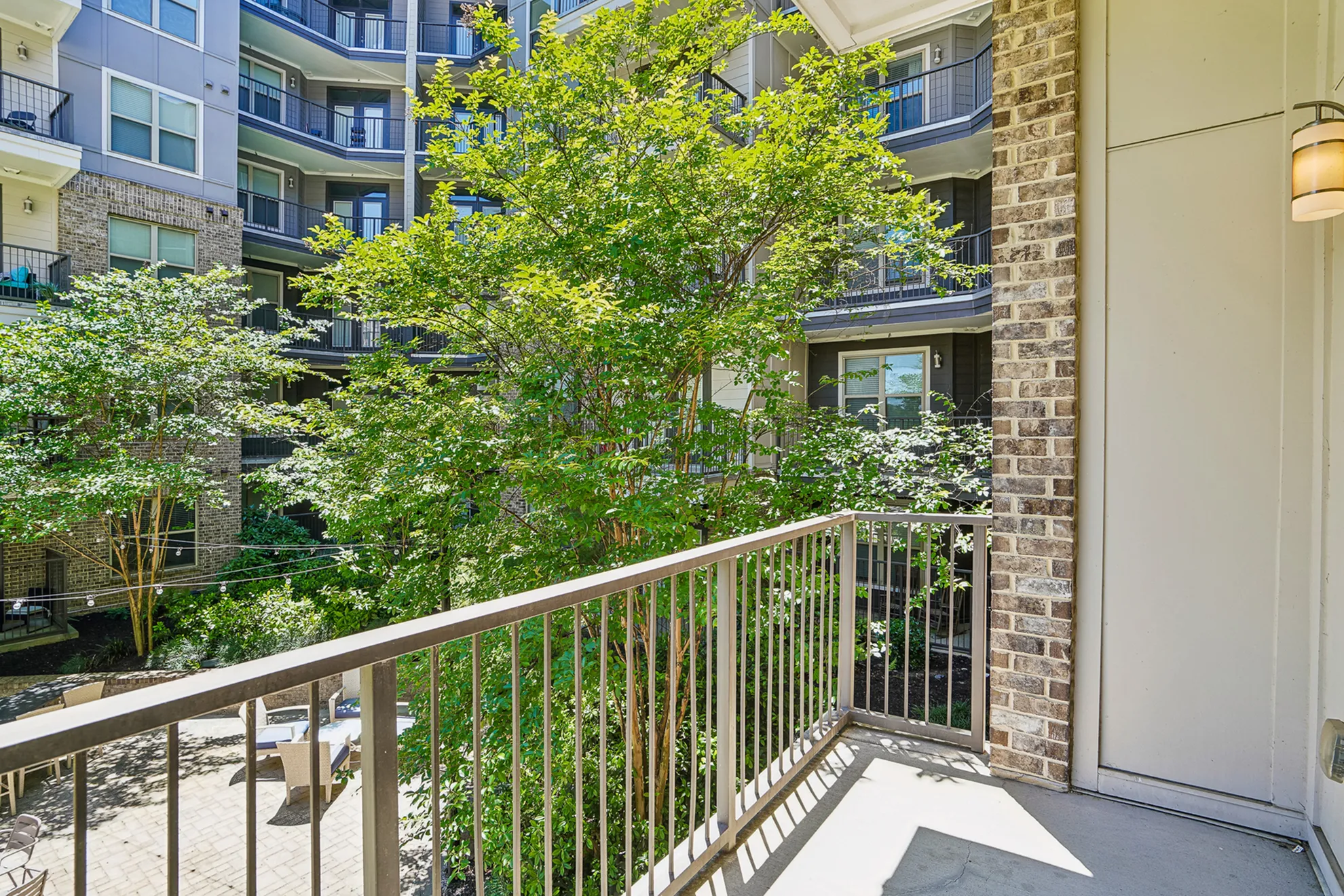 Charming apartment balcony with green courtyard views, perfect for relaxation.