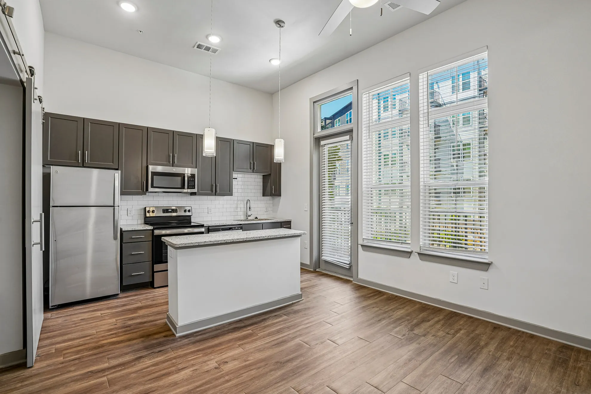 Modern kitchen with sleek cabinets, stainless steel appliances, and a stylish breakfast bar, complemented by large windows and elegant lighting.