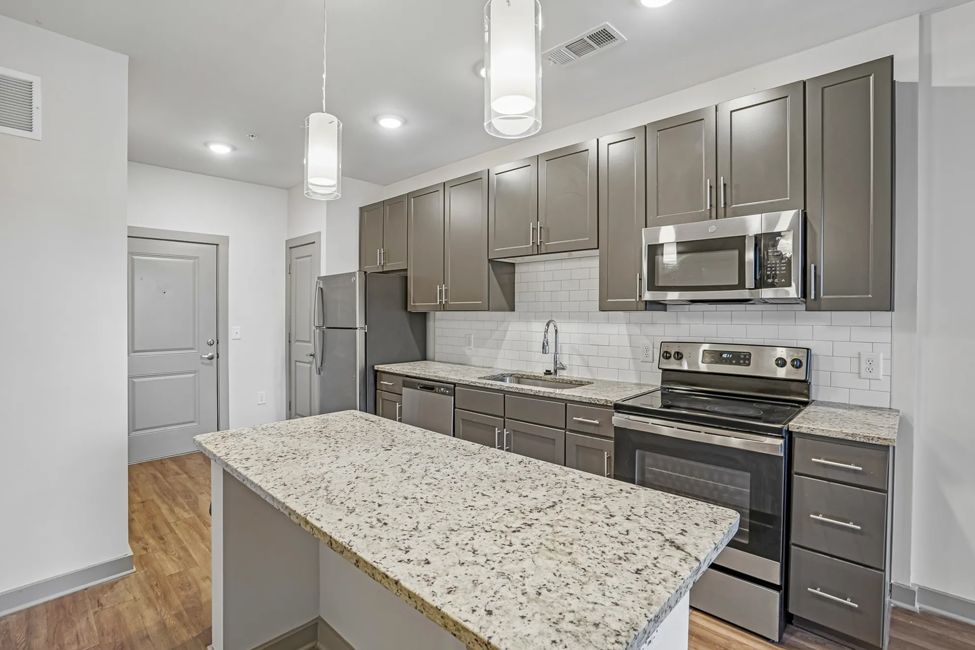 Modern kitchen with sleek appliances, granite countertops, and elegant cabinetry, offering a stylish and inviting space.