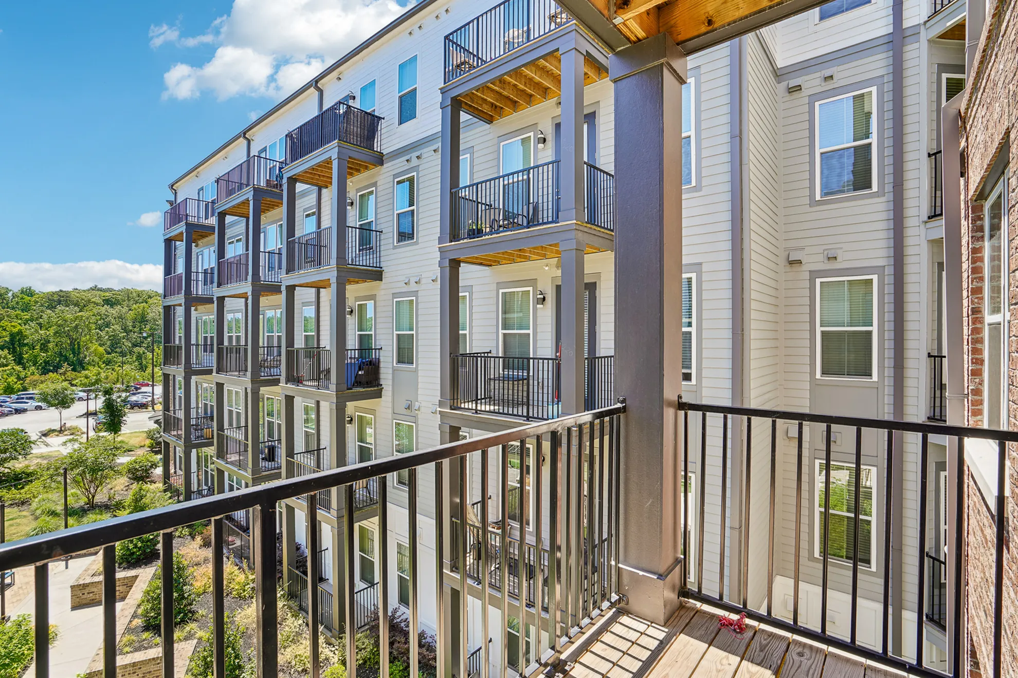 Modern apartment building with spacious balconies and lush green surroundings, offering a perfect blend of comfort and nature.