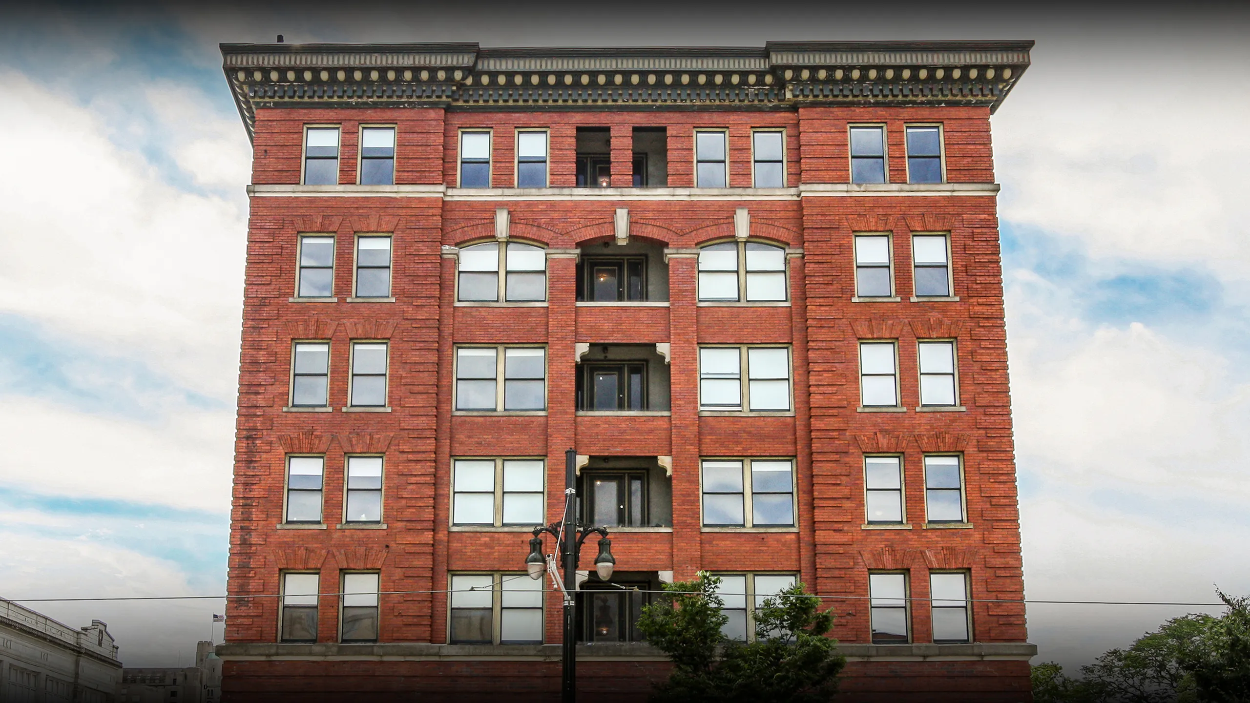 Impressive red brick apartment building showcasing elegant architecture with large windows and historic charm.
