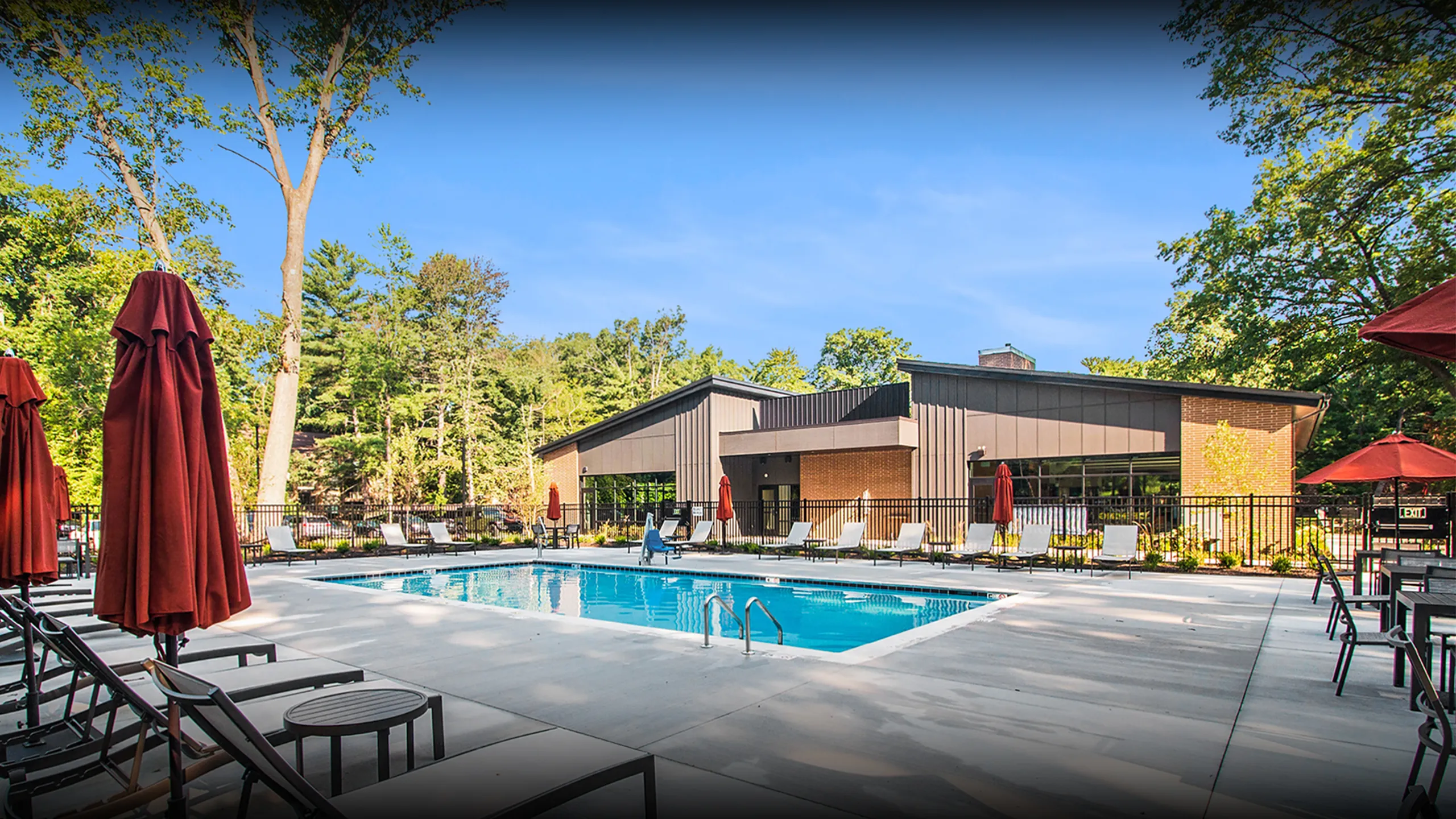 Inviting outdoor swimming pool area with modern architecture and lush greenery, perfect for relaxation and gatherings.
