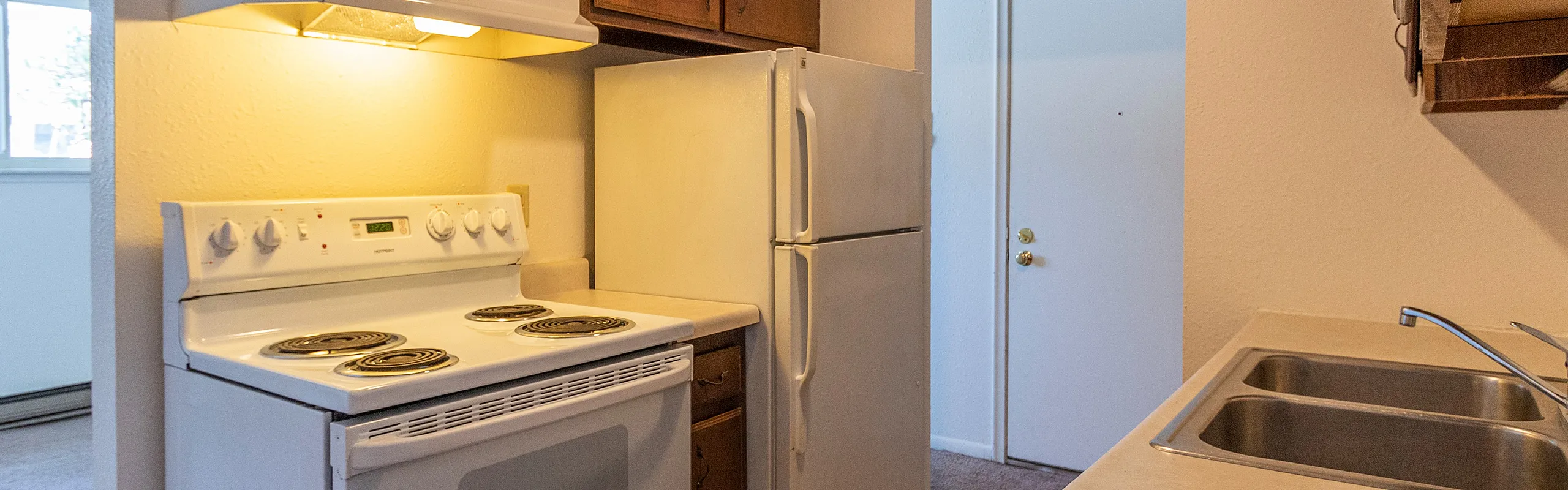 Charming kitchen with warm wooden cabinets, modern stove, and spacious countertop, perfect for culinary adventures.
