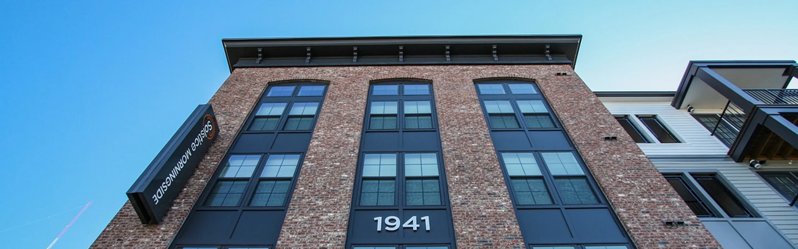 Charming, modern brick apartment exterior with large windows and elegant design, featuring the year 1941 prominently displayed.
