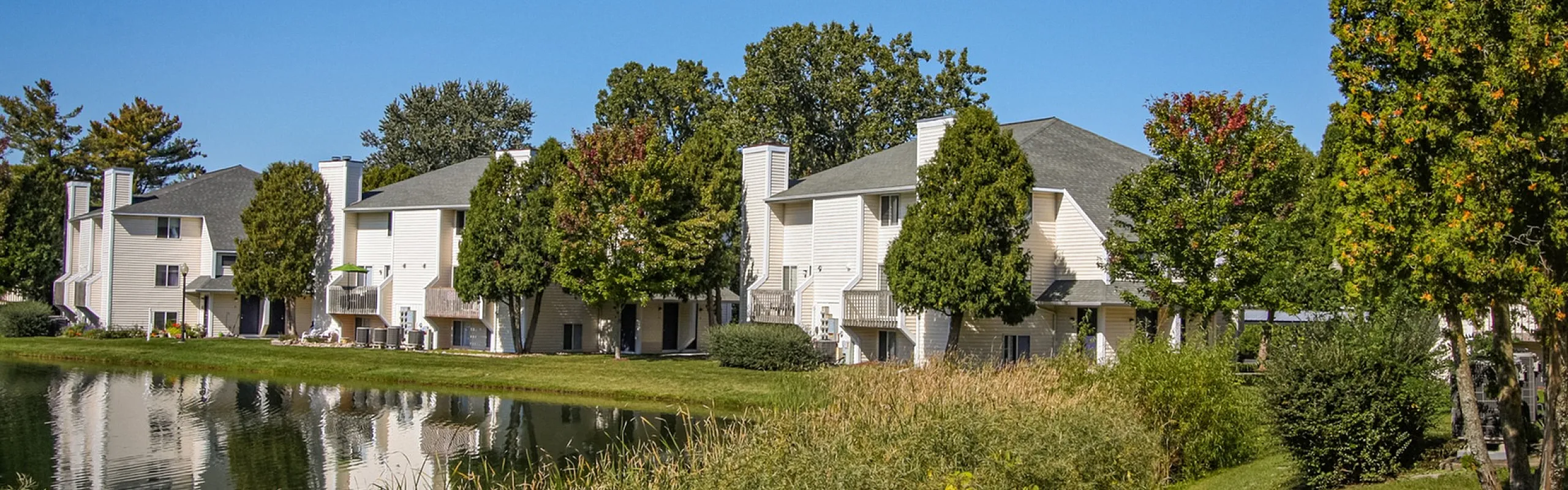 Charming lakeside apartment complex with lush greenery and scenic views, ideal for nature lovers seeking a serene lifestyle.