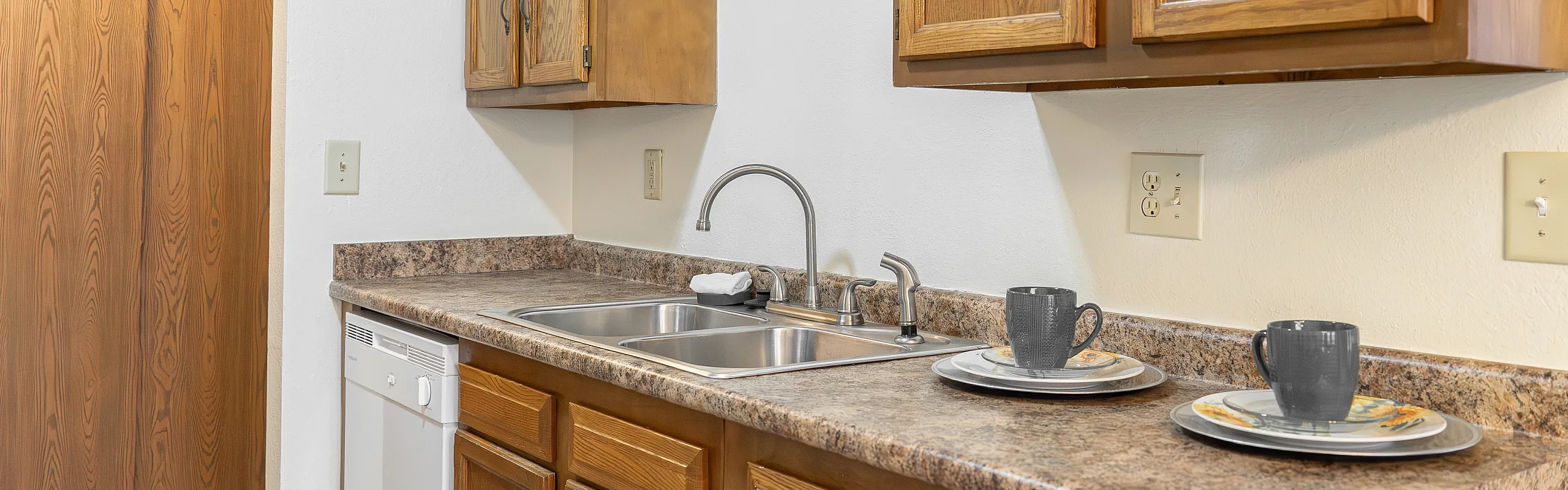 Charming kitchen corner with warm wood cabinets, sleek countertops, and modern sink area, creating a cozy and functional space.