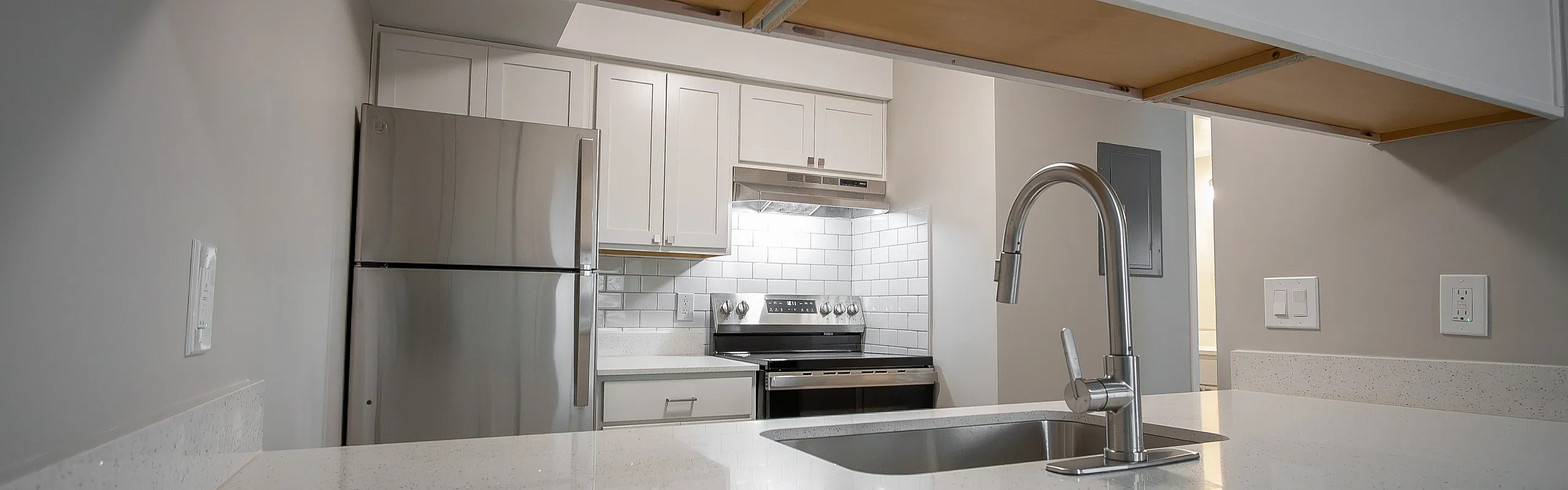 Modern kitchen with stainless steel appliances, sleek white cabinetry, and a stylish tile backsplash.