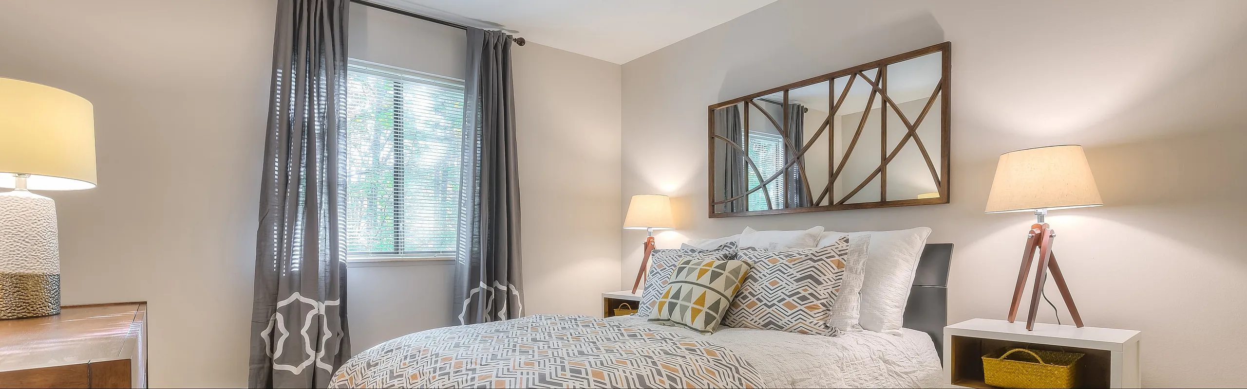 Inviting bedroom with elegant decor, large window, and stylish lighting creating a cozy ambiance.