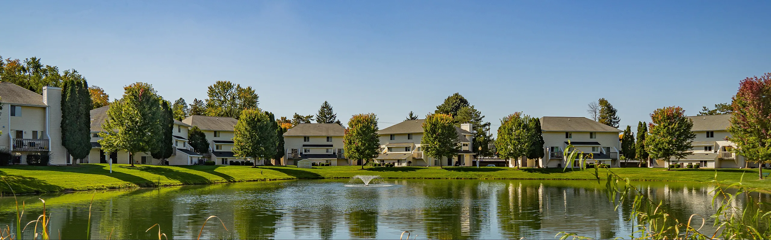 Charming lakeside apartment complex with scenic views and lush greenery, perfect for tranquil living.