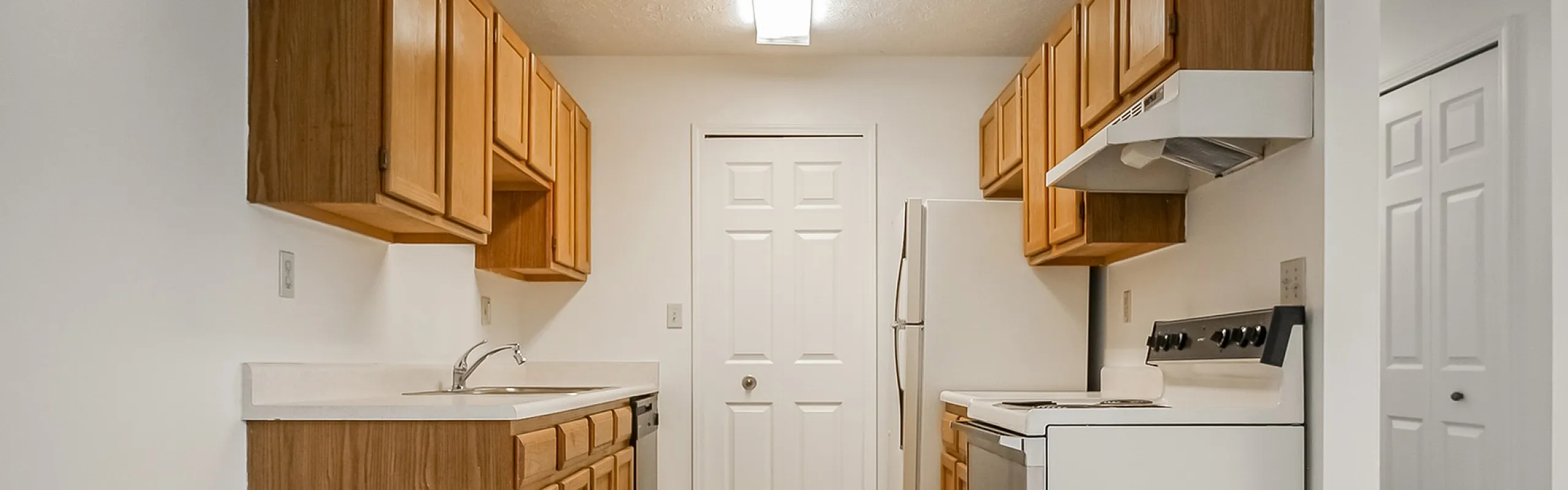 Inviting kitchen with sleek appliances, ample wooden cabinetry, and bright lighting, ideal for culinary enthusiasts.