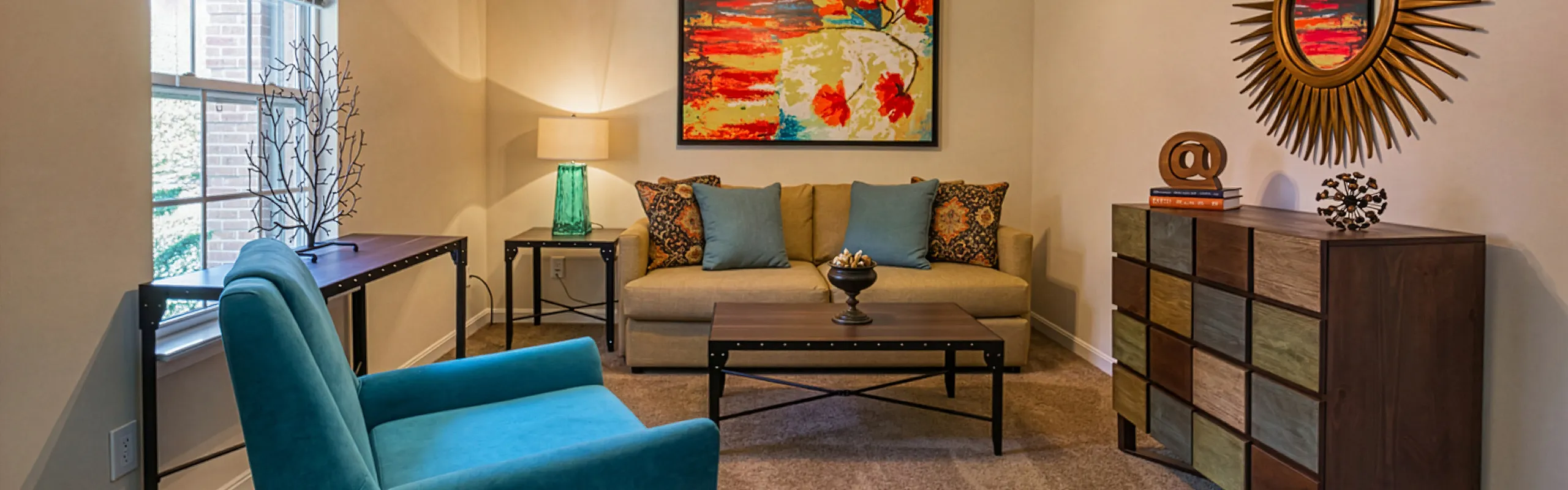 Cozy and stylish living room with vibrant artwork, modern furniture, and natural light creating an inviting atmosphere.