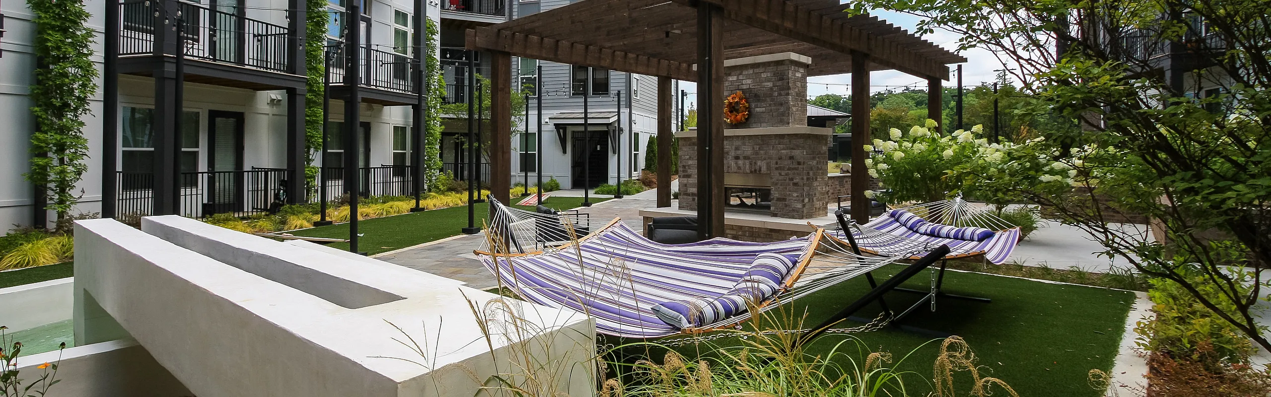 Chic outdoor space featuring comfortable hammocks, a rustic pergola, and lush greenery for a perfect relaxation spot.