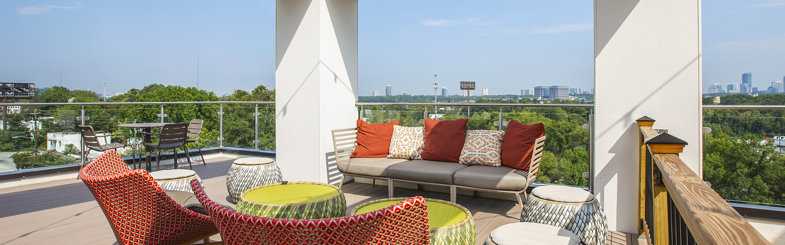 Elegant rooftop terrace featuring stylish seating with colorful cushions and a stunning panoramic city view.