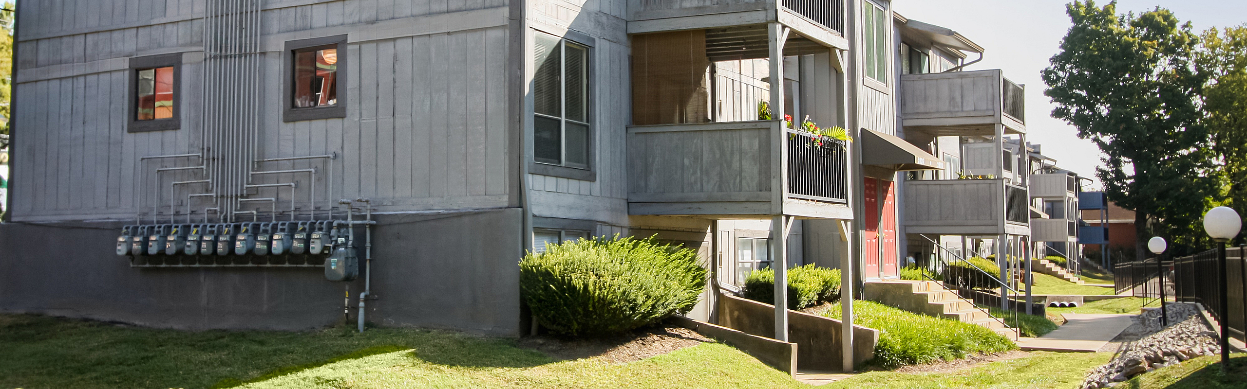 Charming apartment complex with modern architecture, featuring cozy balconies and lush landscaping.