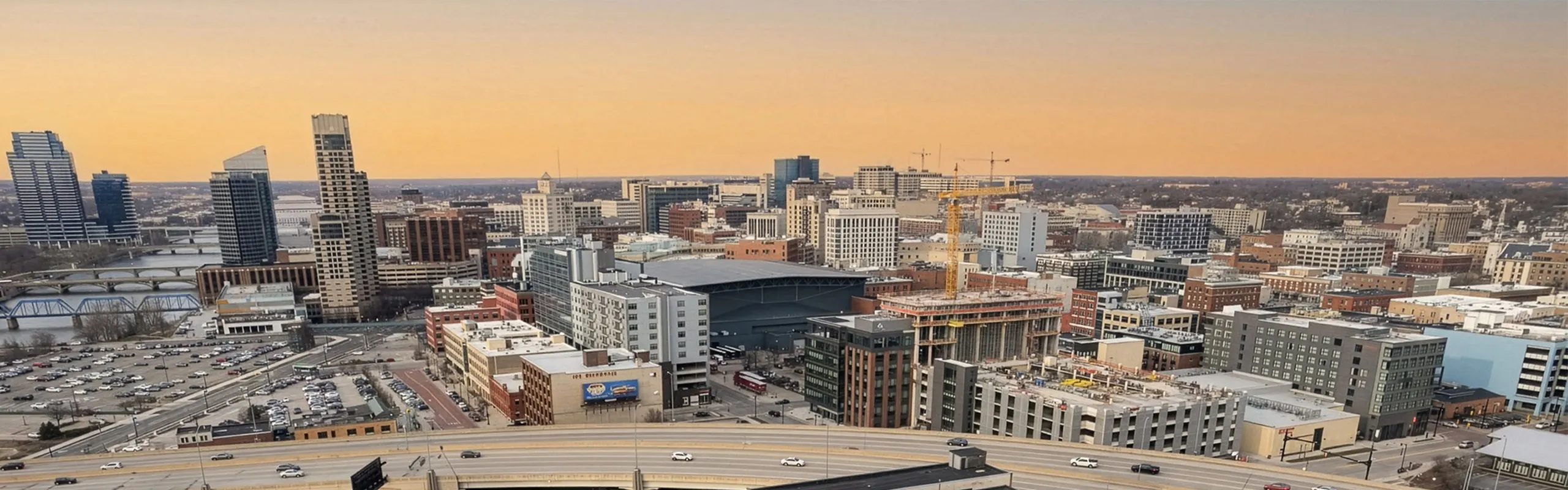 Vibrant urban skyline view at sunset showcasing modern architecture with a mix of high-rise and mid-rise buildings, highlighting the city's dynamic growth.