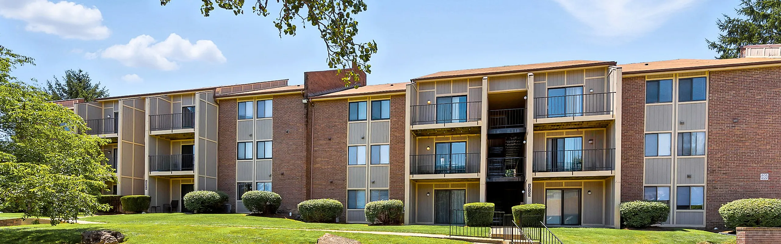 Charming apartment complex showcasing modern design with spacious balconies and lush greenery, perfect for comfortable living.