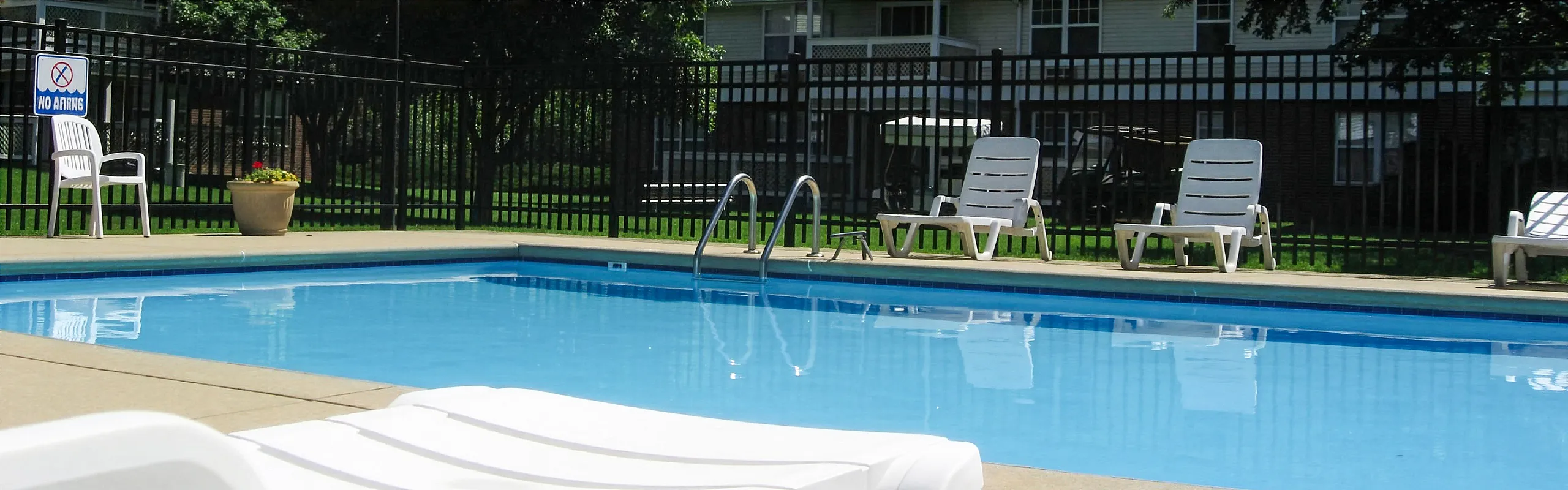 Inviting outdoor pool area with comfortable lounge chairs and lush surroundings, perfect for relaxation.