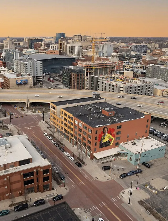 Vibrant urban aerial view showcasing a bustling cityscape with modern architecture and a striking mural on a prominent building.