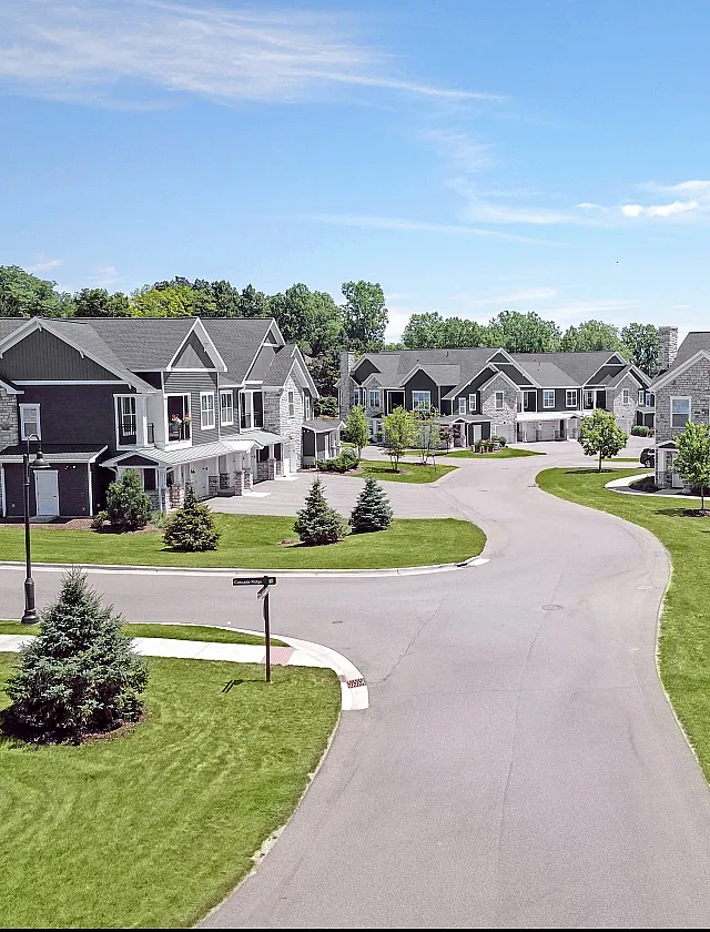 Charming residential community displaying elegant townhomes surrounded by lush greenery and peaceful pathways, perfect for modern living.
