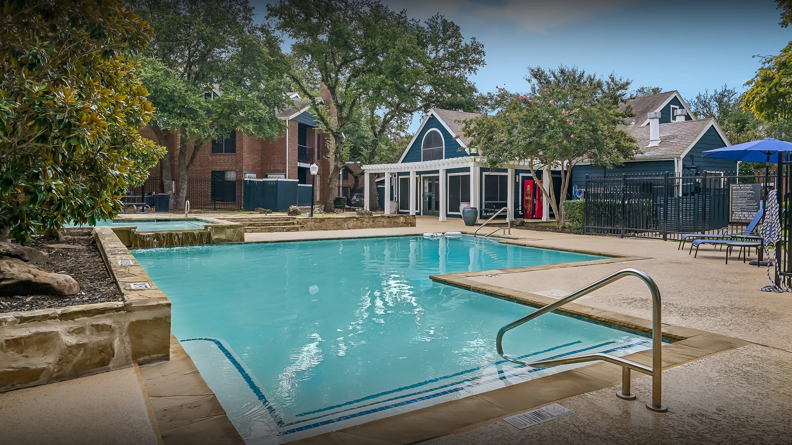 Inviting outdoor pool area surrounded by lush greenery and modern architecture, perfect for relaxation and leisure.