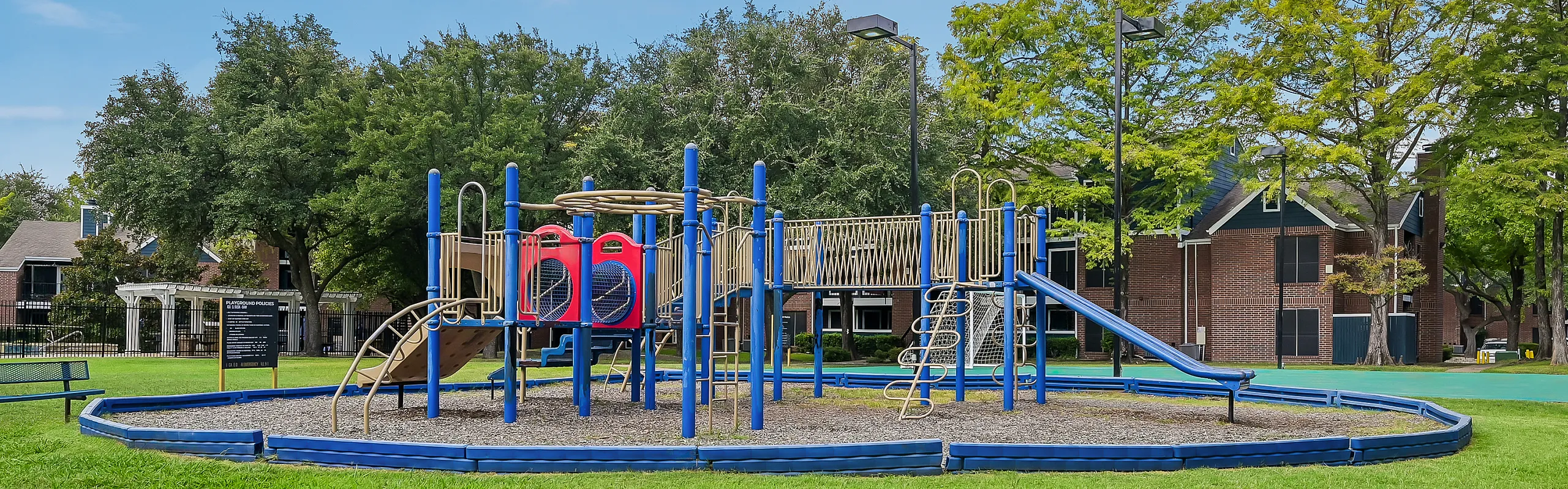 Inviting playground with vibrant play structures and lush greenery in a charming residential community.