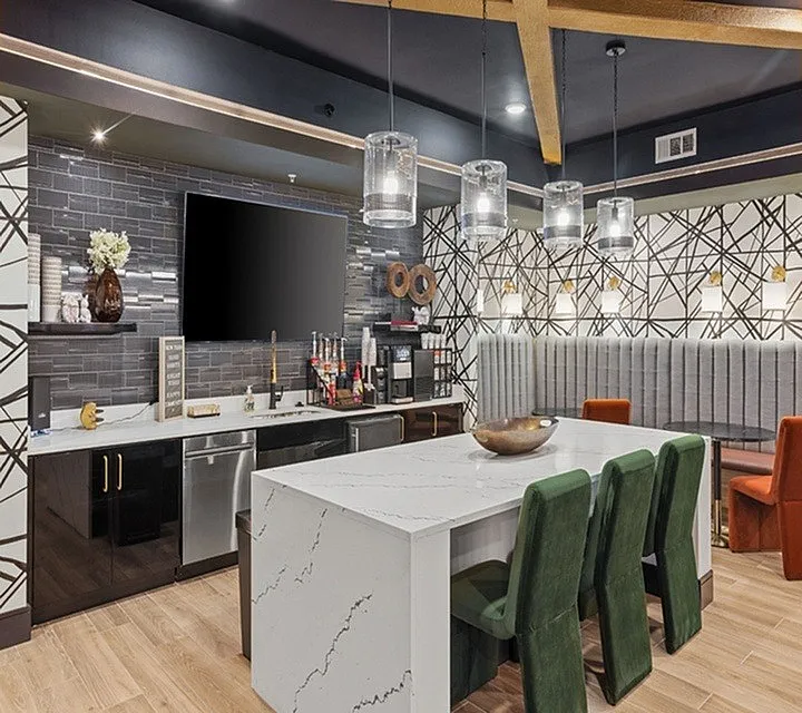 Modern kitchen with sleek countertops, stylish bar seating, and elegant pendant lighting, perfect for entertaining.