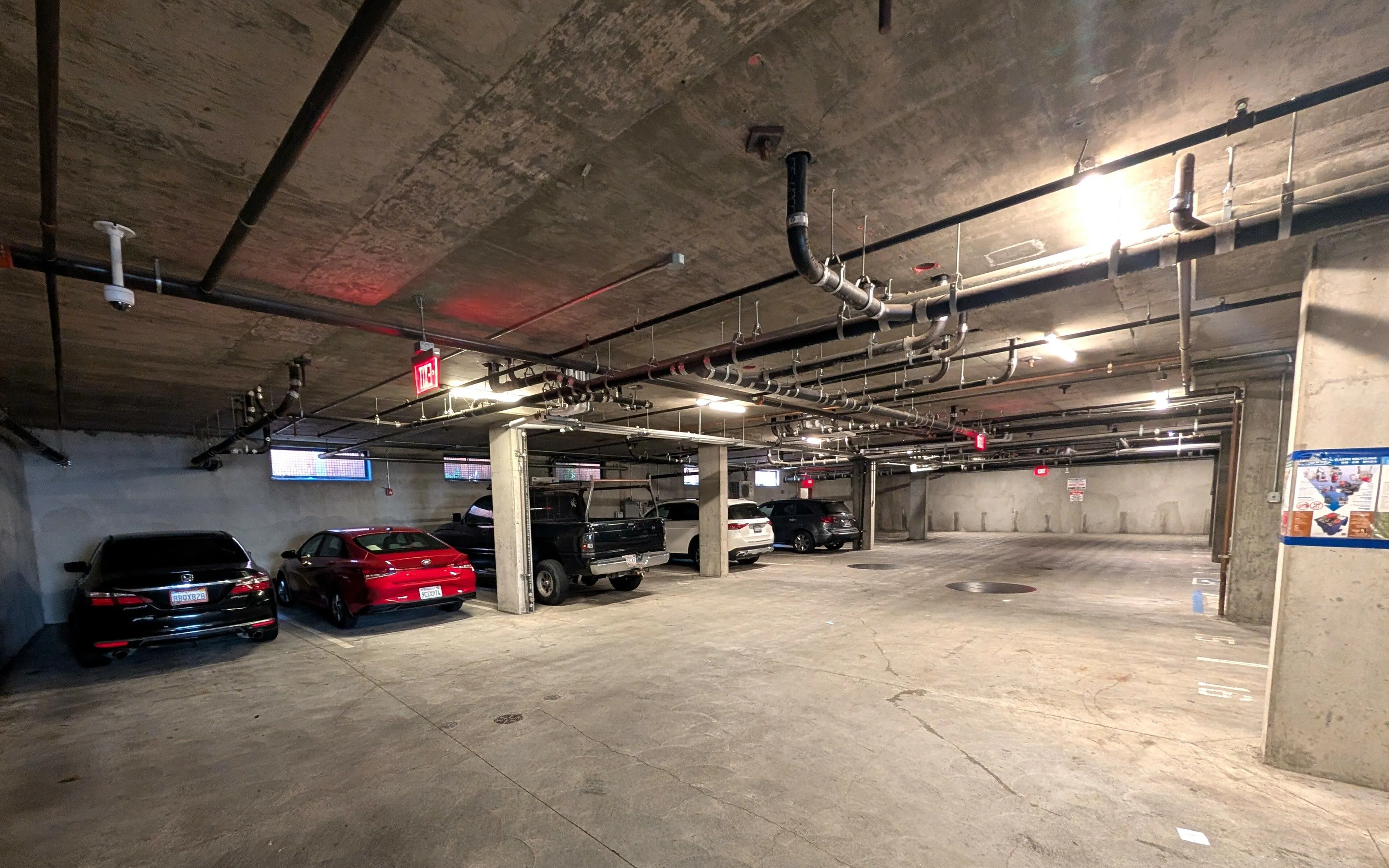 Spacious underground parking garage featuring ample lighting and secure parking spaces, ideal for resident convenience.