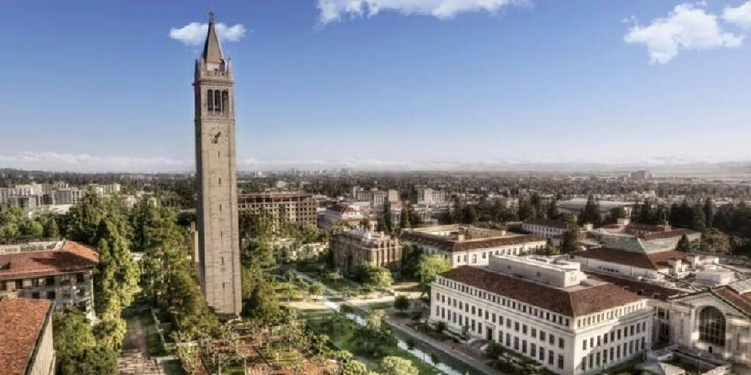 Stunning aerial view of a university campus with iconic clock tower surrounded by lush greenery and historic architecture under a vibrant blue sky.
