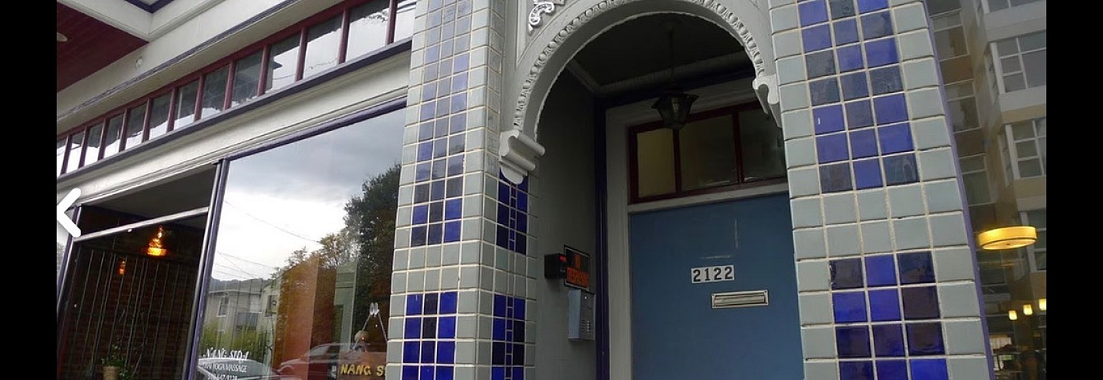 Charming apartment entrance featuring distinctive blue-tiled facade and elegant architectural details.