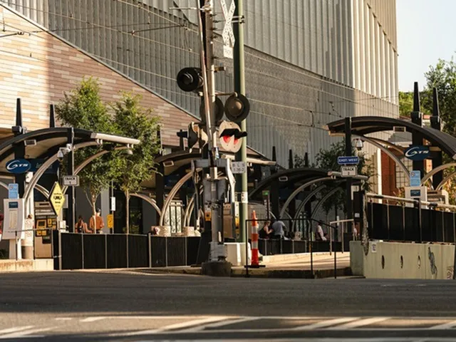 Modern urban street scene with stylish architecture and sleek public transit station.