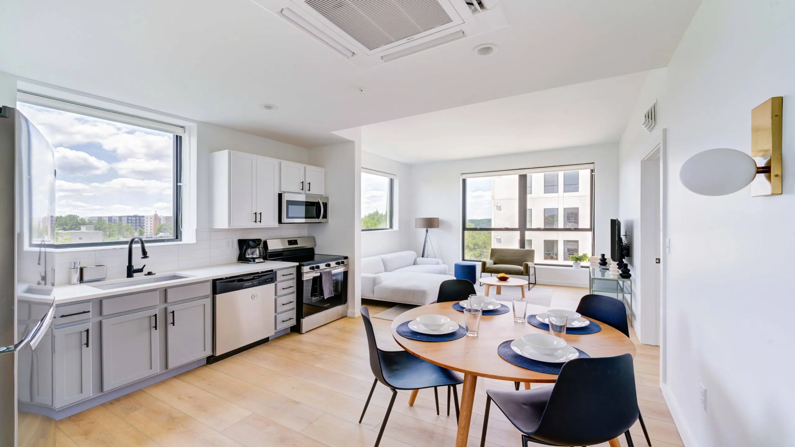 Bright, modern apartment with open-concept kitchen and living room featuring elegant finishes, abundant natural light, and stunning city views.