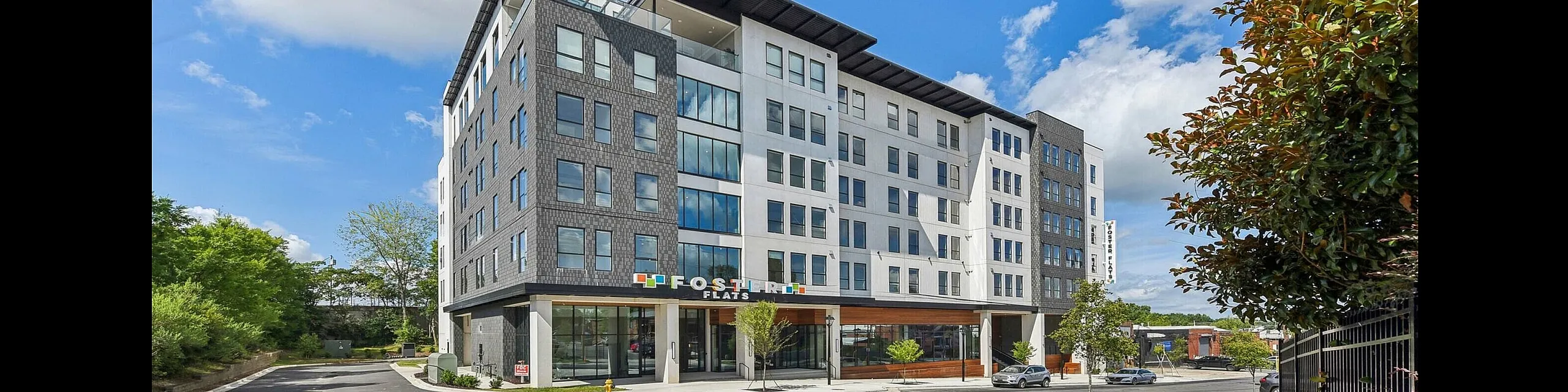 Modern urban apartment building with sleek architectural design, featuring a prominent facade and inviting entrance.
