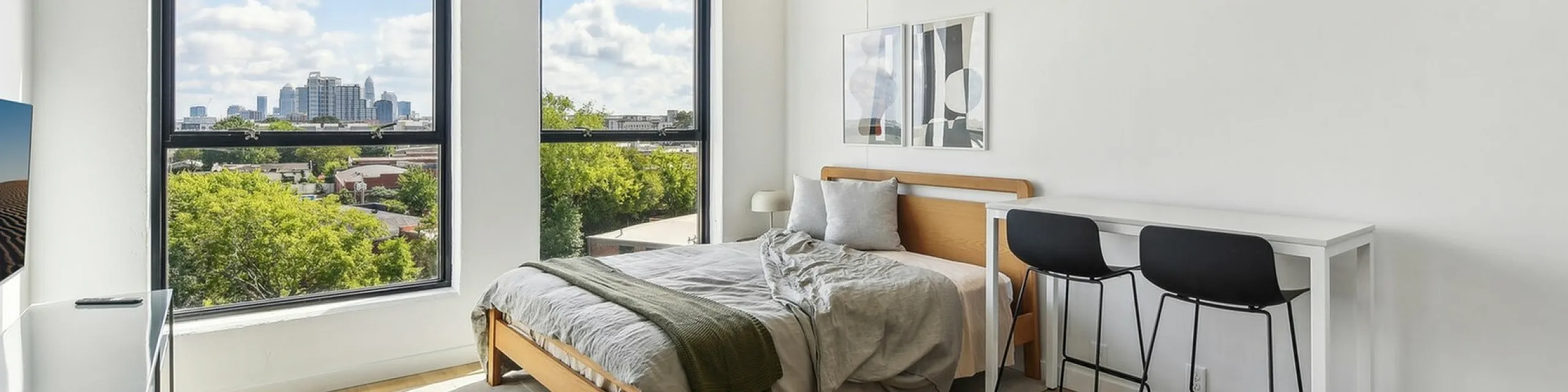 Bright and airy modern bedroom with city skyline views, featuring sleek furniture and a minimalist design for ultimate comfort.
