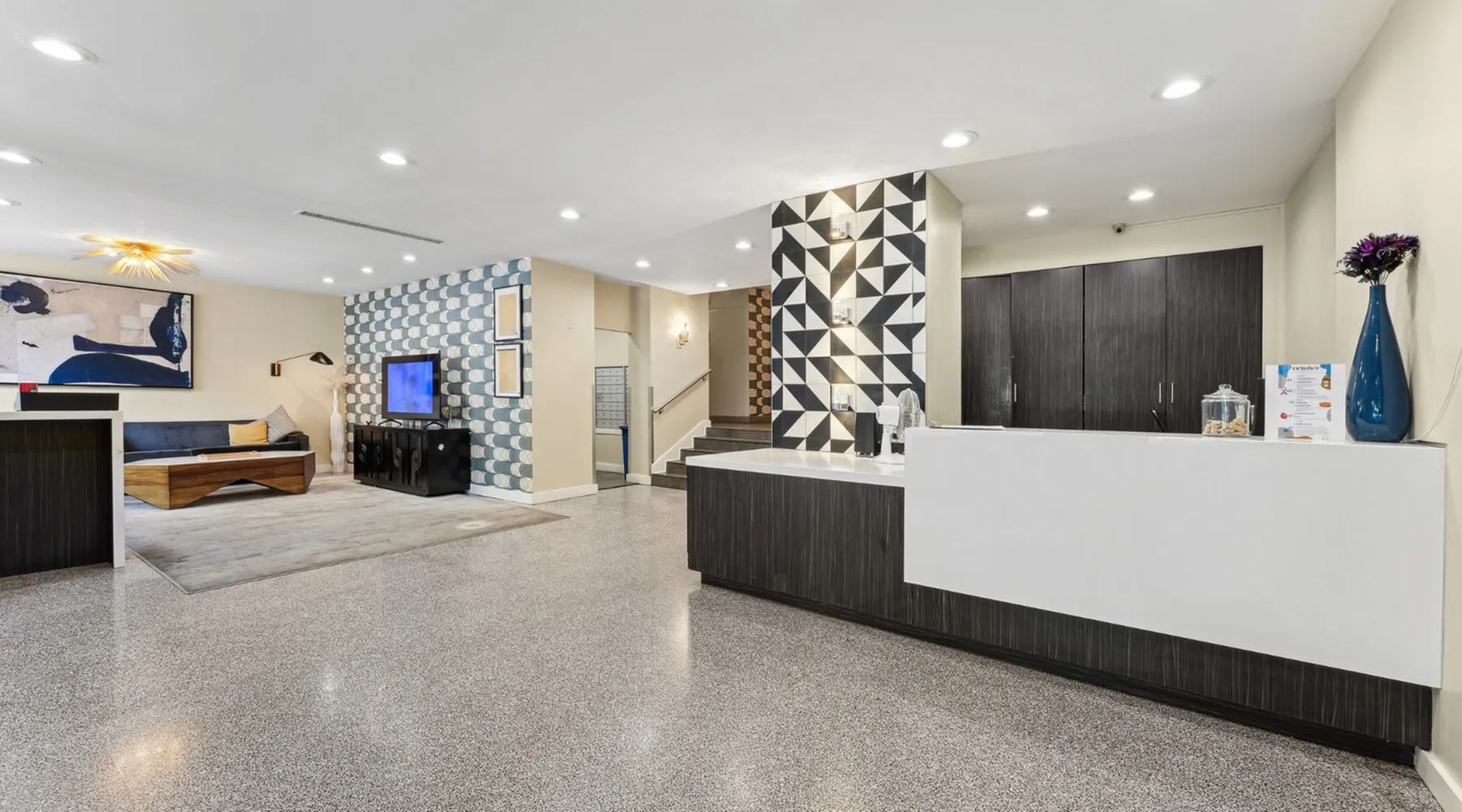 Chic modern lobby showcasing geometric accent walls, sleek furnishings, and elegant decor with a touch of contemporary art.