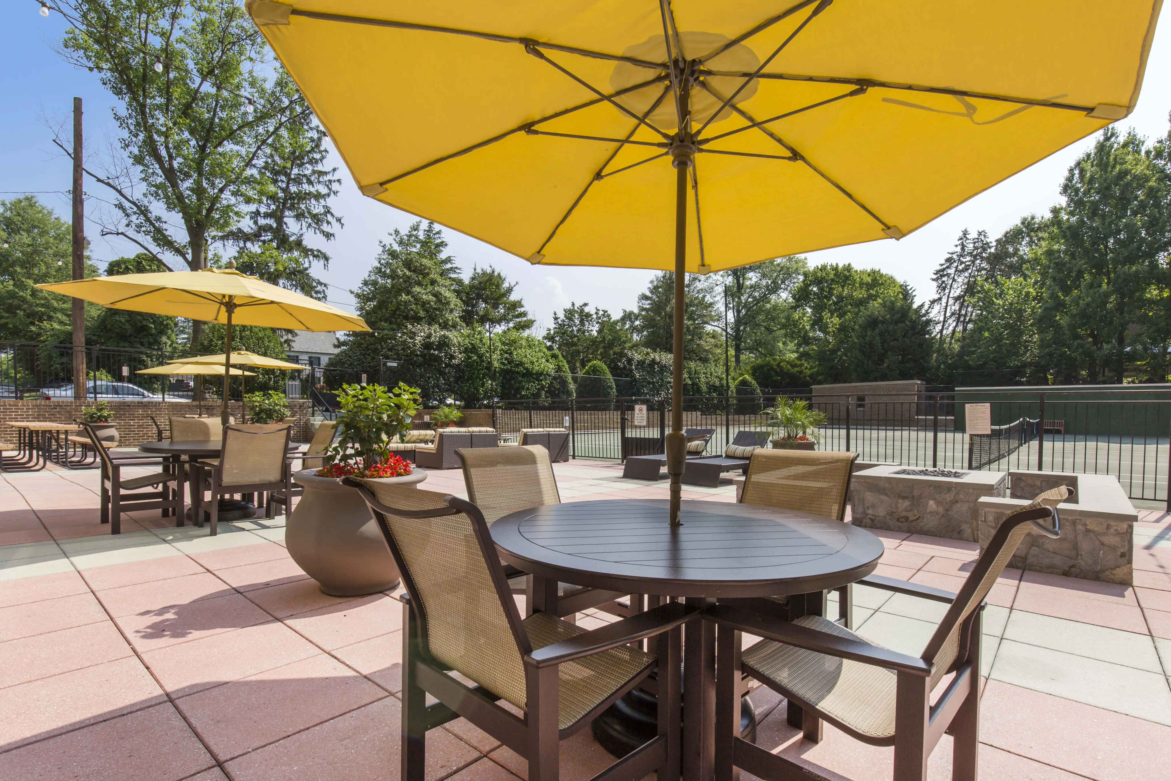 Inviting outdoor patio area featuring modern furniture and vibrant yellow umbrellas, perfect for relaxing and entertaining.