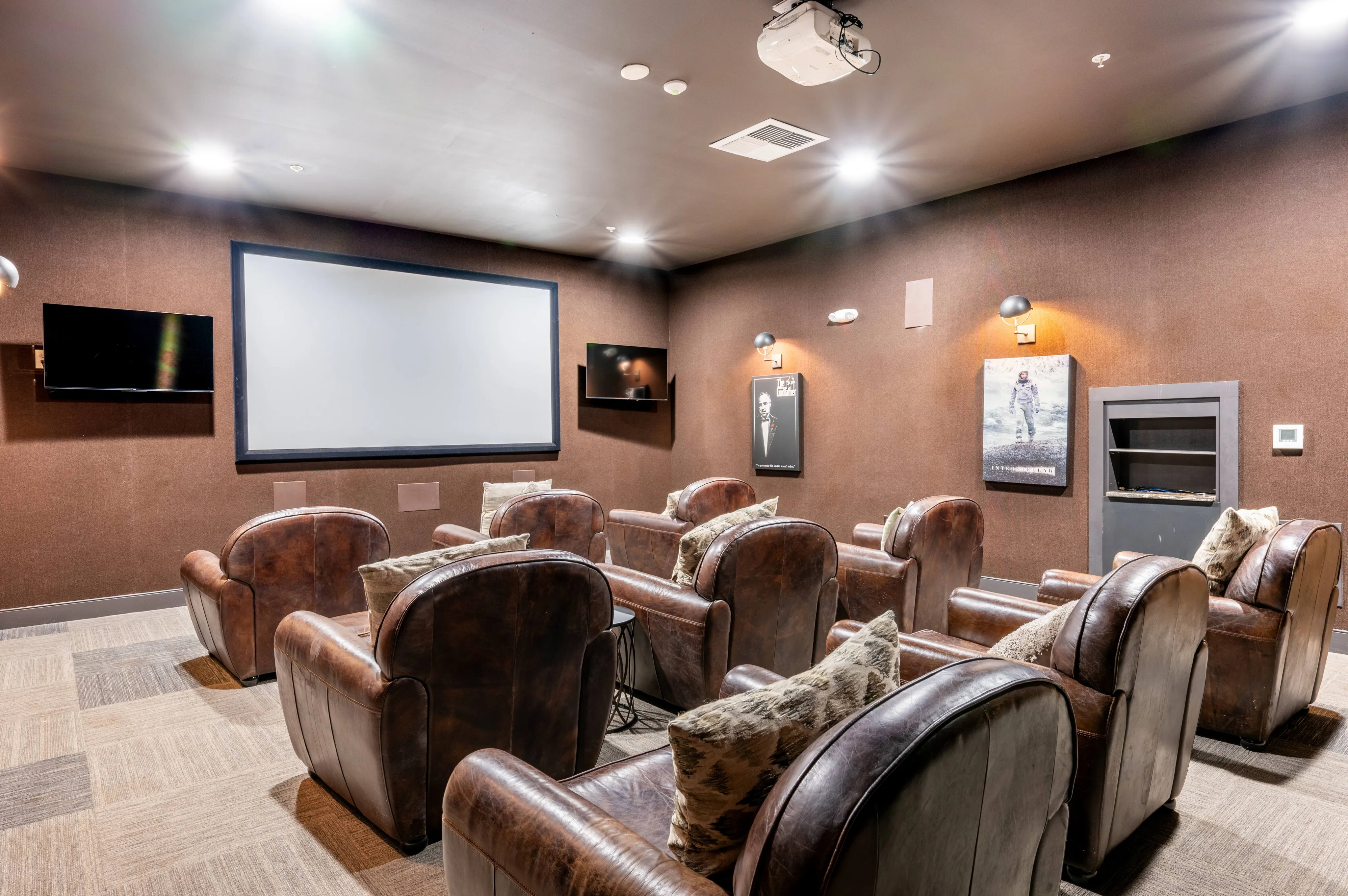 Luxury home theater room featuring plush leather seating, ambient lighting, and a large screen for an ultimate cinematic experience.