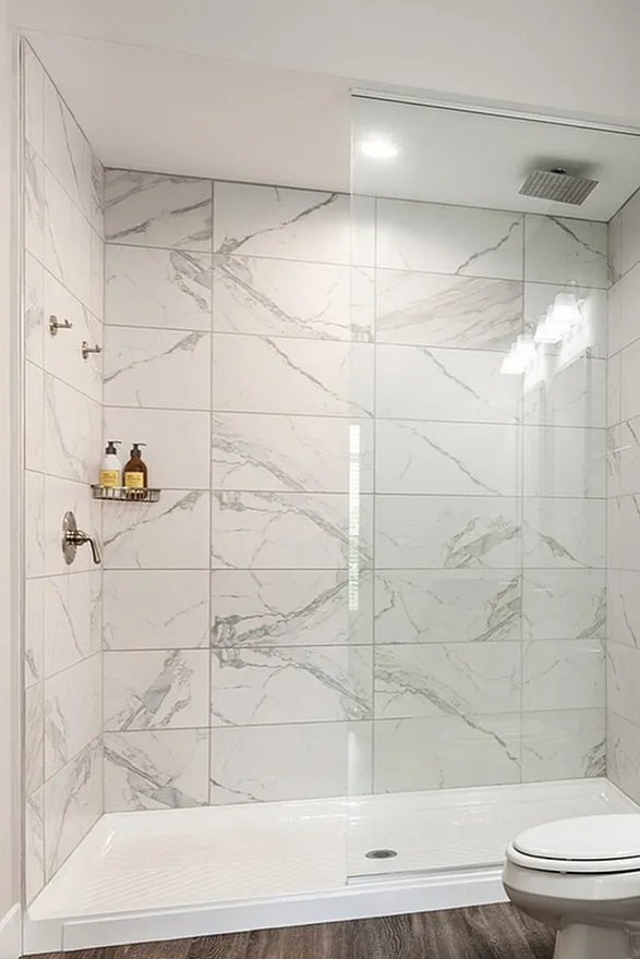 Luxuriously designed bathroom with marble shower, dual sinks, and walk-in closet showcasing modern elegance.
