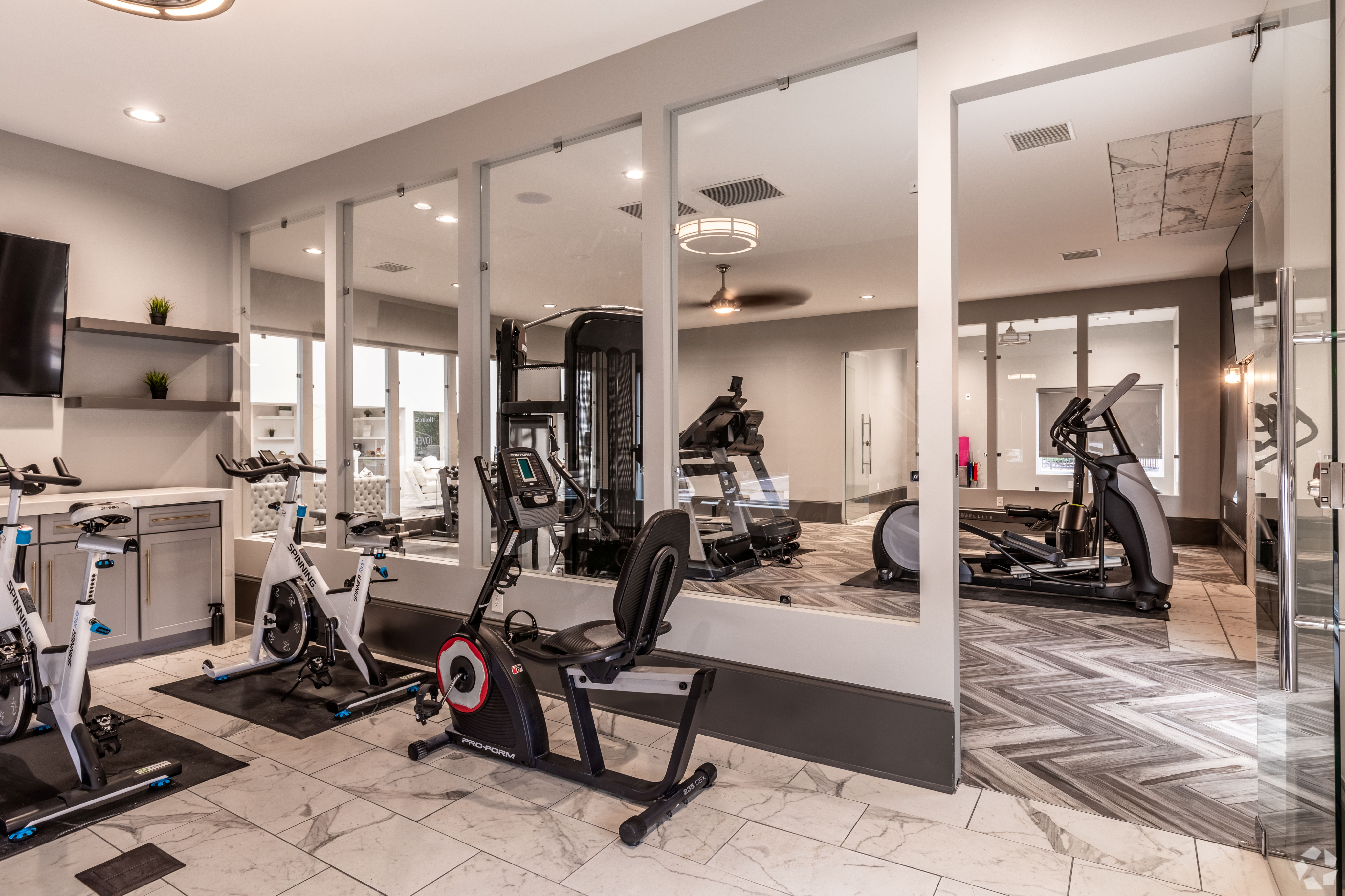 Modern fitness center with state-of-the-art exercise bikes, elliptical machines, and a serene environment for an invigorating workout experience.
