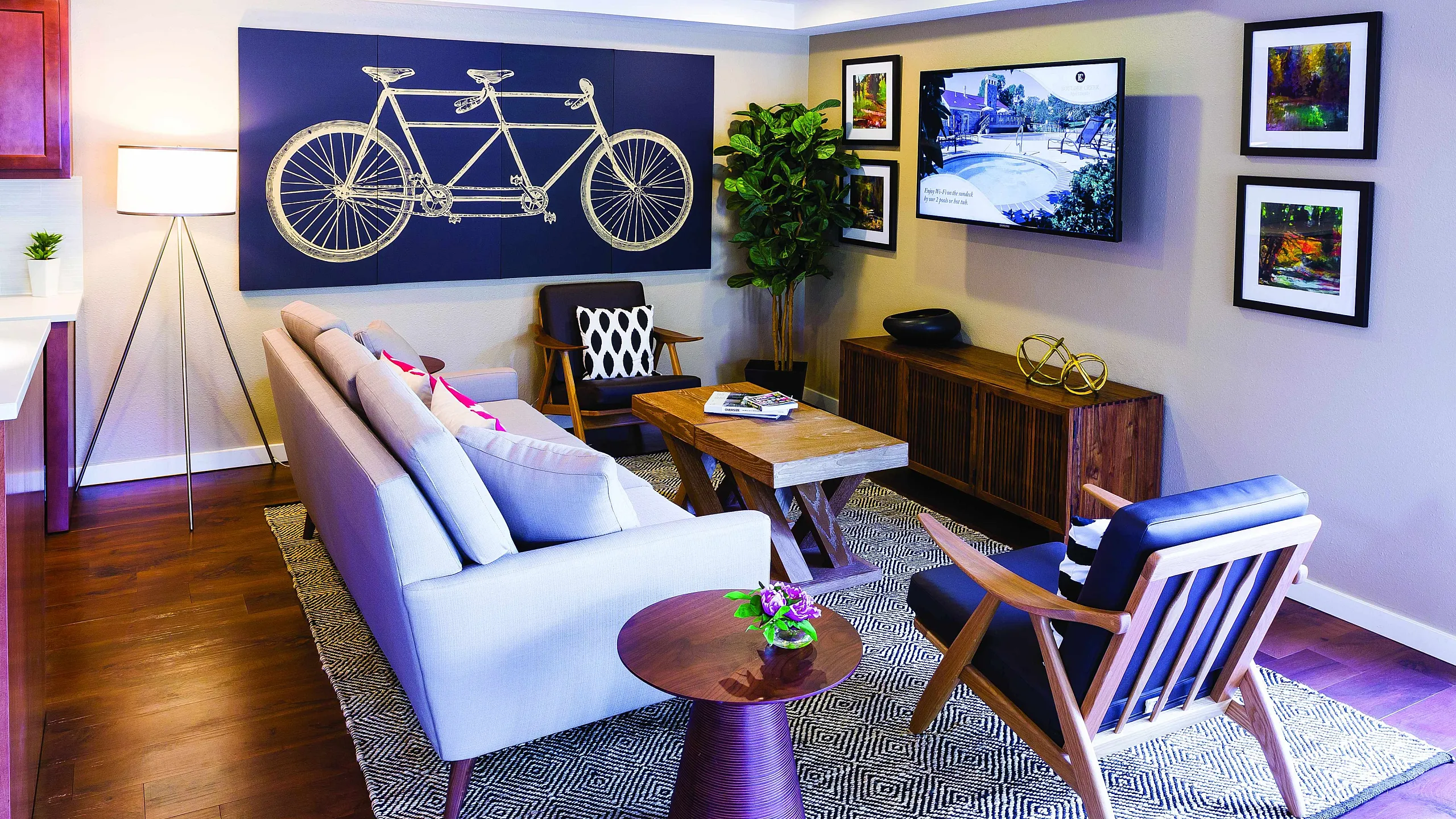 Contemporary living room with elegant seating, stylish decor, and vibrant artwork on warm wooden floors.