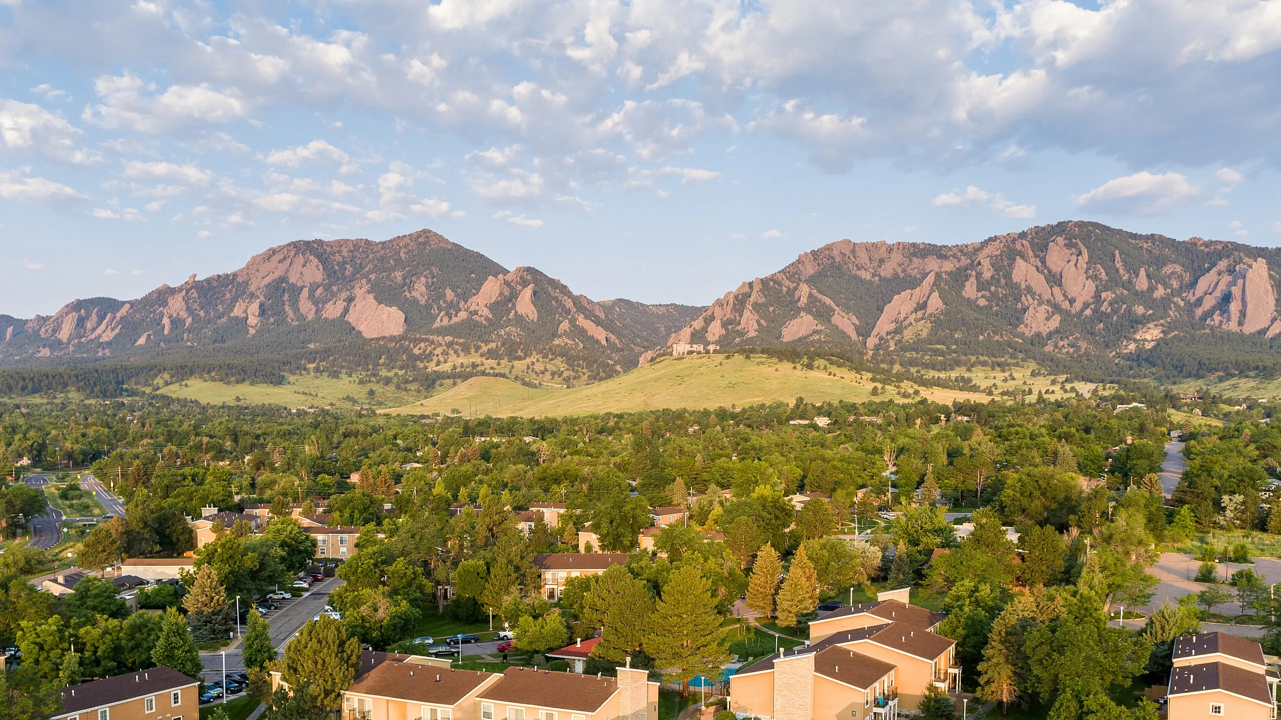 Charming apartment complex nestled in lush greenery with mountain views, offering tranquility and scenic beauty.