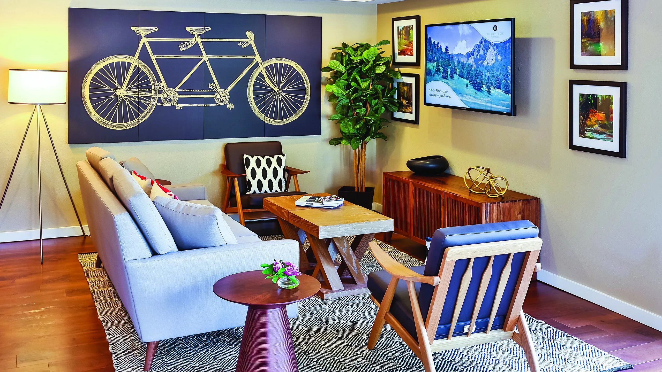 Inviting and stylish living room with modern decor, featuring a cozy gray sofa, elegant artwork, and a vibrant indoor plant, perfect for relaxation and entertaining.